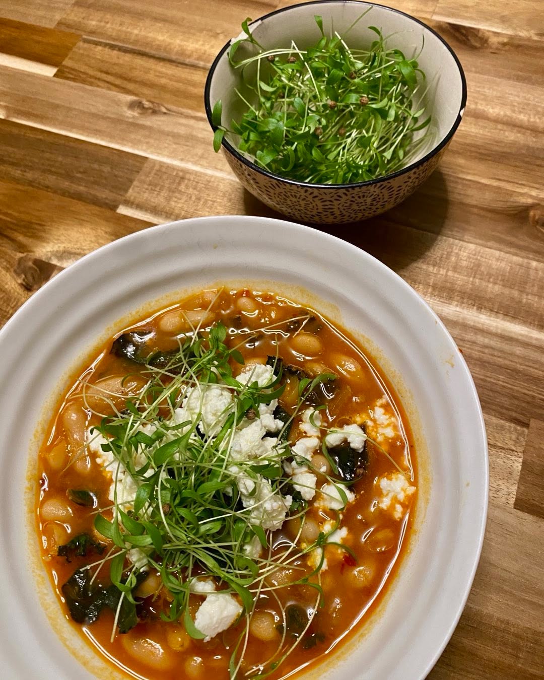 Spicy white bean stew topped with micro cilantro 🌿