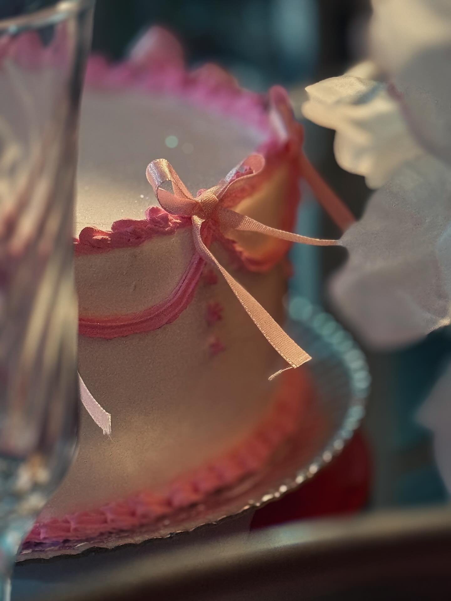 Bolo de morango com decoração de lacinhos.