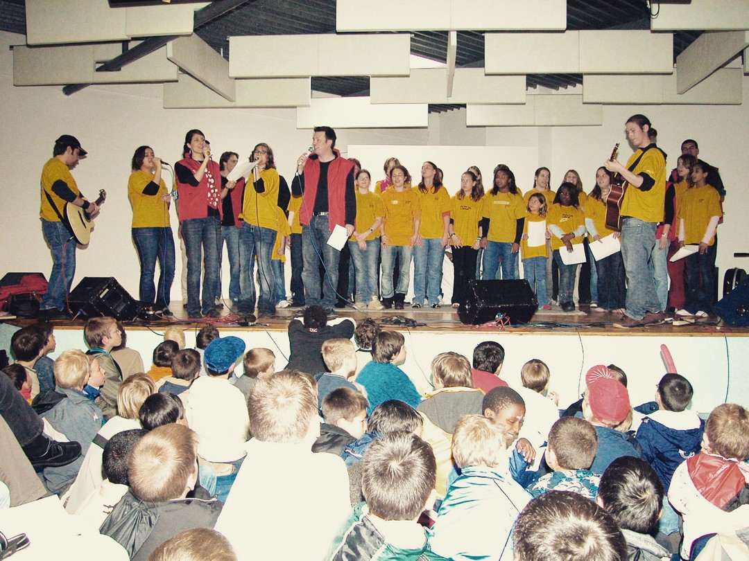 Les Fabricants de Joie – Qui sommes-nous ? « Certains pensent comment pourrions-nous fabriquer la joie ? » Ces paroles de la fameuse chanson « Fabricants de Joie », sur laquelle nous avons dansé dès 1987, amorcent la réponse à cette question. Contrairement à ce que pensent certaines personnes qui téléphonent au bureau FJ, nous ne sommes pas des fabricants de poussettes de la marque « Joie ». Nous ne sommes pas non plus (ou pas seulement) des « enfants qui dansent dans la rue ». Mais alors qui sommes-nous vraiment ? A suivre sur: https://www.jeunesse-en-mission.ch/fr/post/les-fabricants-de-joie-qui-sommes-nous
Les Fabricants de Joie (FJ or King's Kids) - Who are we? “Some people think, “How can we manufacture joy? These words from the famous song “Fabricants de Joie” ("Joy makers"), to which we danced back in 1987, begin the answer to that question. Contrary to what some people who phone the FJ office think, we are not manufacturers of “Joie” brand strollers. Nor are we (or are we only) “children who dance in the street”. So who are we really? To be continued on: https://www.jeunesse-en-mission.ch/post/les-fabricants-de-joie-fj-or-king-s-kids-who-are-we