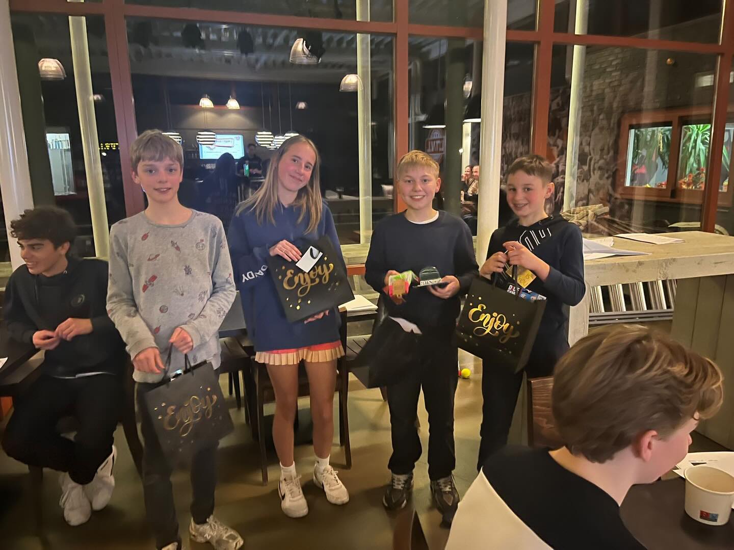 Jonge LTVL’ers dagen elkaar uit tijdens Jeugd Pubquiz
Een dag na de Pubquiz voor de volwassen leden van LTVL, was het de beurt aan de (oudere) jeugd. Zo’n twintig kinderen gingen in teams van 3 of 4 aan de slag en kraakten hun hersenen over vragen in de categorieën Dieren & Mensen, Muziek, Geschiedenis & Topografie, Sport & Spel, de Fotoronde en TV-servies & Films. Quizmaster Lars had de lat hoog gelegd, maar gelukkig kon host Naomi de deelnemers af en toe ondersteunen met een (subtiele) hint.
Tussen de rondes door werd er genoten van een potje padel, saucijzen- en kaasbroodjes van @Bakker Prins en andere (borrel)hapjes, met dank aan Team Patat achter de bar. Daarnaast waren er bonuspunten te verdienen met de leukste teamnaam en – net als bij de volwassenen – vliegtuigje vouwen en gooien. Dat laatste kon de jeugd natuurlijk veel beter dan de oude garde ;-)
Om 22.15 uur was het tijd voor de uitslag. De teams lagen veelal dicht bij elkaar, maar team De Gebakken Peren stak er toch bovenuit. Logan, Per, Tobey en Zeno gingen er met de winst en de cadeautas vandoor. De Jeugdcommissie kijkt terug om een geslaagde eerste editie, waarbij de oudere jeugd elkaar op een andere manier leerde kennen. Dit smaakt zeker naar meer!
Dit was de eerste activiteit voor de jeugd in 2026. Binnenkort komt de Jeugdcommissie bij elkaar om te kijken wat we nog meer gaan doen dit jaar. Heb jij leuke ideeën? Stuur ze dan naar jc@ltvl.nl en wie weet komt jouw idee op de activiteitenkalender!
