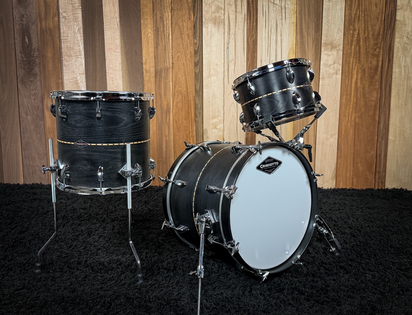 Custom Shop Ash with Maple inlay, 45 degree bearing edges, and black stain/ oil finish. Sizes are: 8x12, 14x14, and 14x18 with T-rods on the bass drum.