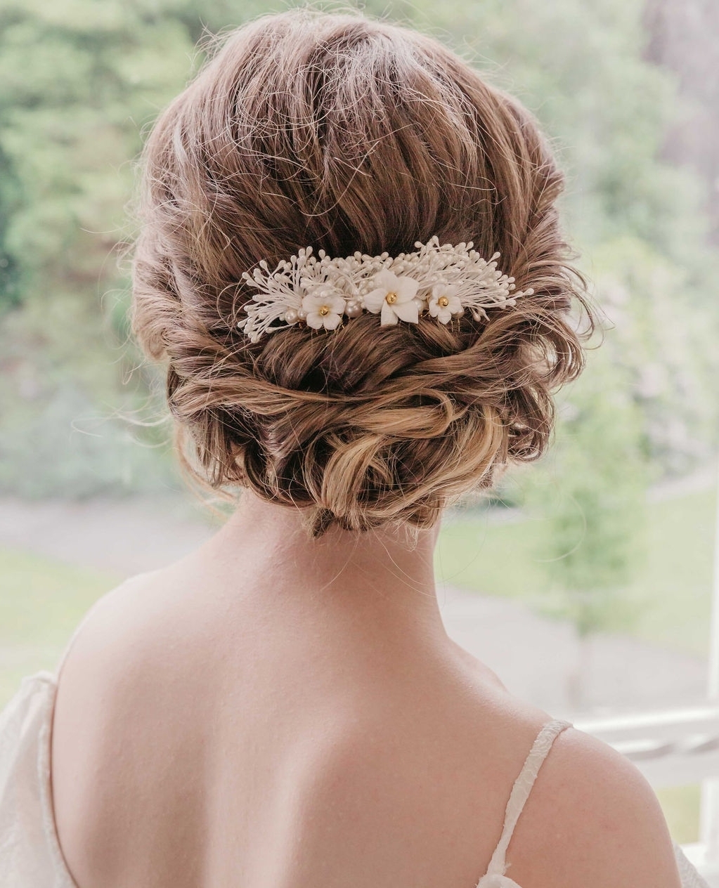 D E L I C A T E - i am fairly well known for creating beautiful yet bold designs but you will also find lots of delicate and pretty pieces in my collections. This one is a smaller version of my Calanthe, using lots of natural pearly stamens with a delicate row of porcelain flowers.
This design slides easily into the hair as it is made on a comb, so you can be confident it will be secure.
.
.
.
Photography @rosiewoodsphoto
Hair & make up @daniellamakeuphair
Model @jasminetovey
Dress @bridalserendipity
Dress designer @shikobabride
Venue @flixton_house
.
.
.
#bridal #bridetobe #weddingideas #wedding #weddings #modernbride #modernwedding #bohobride #bohowedding #weddingjewellery #weddingjewelry #weddingaccessories #bridaljewellery #bridaljewelry #headpiece #classicbride #elegantbride #wedinspo #engaged #bridesmaids #weddingday #bride #rusticwedding #uniquewedding #weddingplanning #bridetobe2024 #bridetobe2023 #updo #bridalupdo #weddinghair