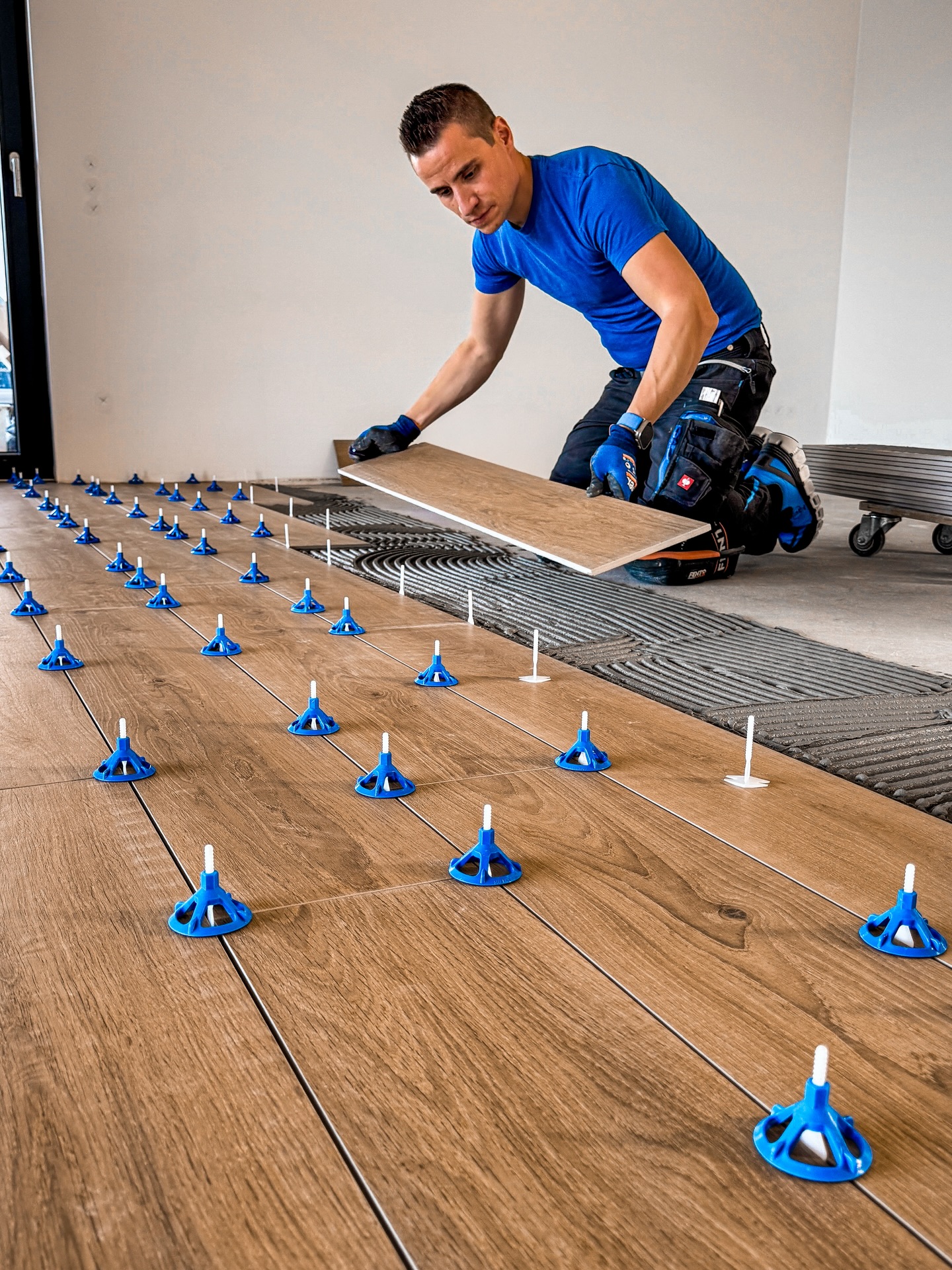 💙
👉🏽 TECHNIK BEITRAG
Heute gibts für Euch einen Technik-Beitrag über meine aktuelle Baustelle 🚧
In diesem Post findet ihr alle Infos über den verlegten Holzfußboden und den neuen Werkzeugen, die wir seit Anfang dieser Woche am Start haben. Zum Ende der Woche haben wir noch mit dem Bad angefangen - davon gibts aber noch nicht viel zu sehen.
Bodenfliese: Marazzi Oltre Caramel
Format: 20 x 120cm
Verband: wild bzw. unregelmäßig
Fugenbreite: 2 mm
Fliesenkleber: Ardex X 78
Fuge: PCI Nanofug Premium Terrabraun
Verlegesystem: @floorvation_gmbh
Mülleimer: @trashmaster_shop
Fliesen Reparaturkit: @karldahm
Niv Duo Box für VLS: @joao_miguel_3d_printing
SOS VLS: @nozardiamant @bihui.tools
Reinigungstücher: @strauss_europe
Stromprüfer: @boschprofessionaldach
Matrix Bohrkronen: @mainwerktools
LED Lampe und Konturenlehre: in meiner Amazon-Liste
(www.amazon.de/shop fliesenlegermeister.johannes)
Warum kam hier keine Entkopplung zum Einsatz?
Es wurde ein neuer Estrich eingebaut und durch das Holzfliesen-Format mit den vielen Fugen kann die Spannung im Fliesenbelag ausreichend abgebaut werden.
Eine Entkopplung wäre zum Beispiel bei einem altem, bestehenden Estrich mit vorhandenen Rissen zum Einsatz gekommen oder wenn großformatige Fliesen ab 100x100cm verlegt worden wären.
Das ist aber lediglich meine persönliche Meinung! Da gibts auch kein Lehrbuch für. Denn eine Entkopplungsmatte ist wie eine Versicherung unter dem Boden. Man hofft eigentlich das man sie nicht benötigt.
Aber wenn sich etwas im Untergrund bewegt oder verändert, ist man verdammt froh, sie eingebaut zu haben.
Wenn Euch solche Technik-Einblicke gefallen, lasst gern ein Like da und schreibt eure Fragen in die Kommentare 👇🔥