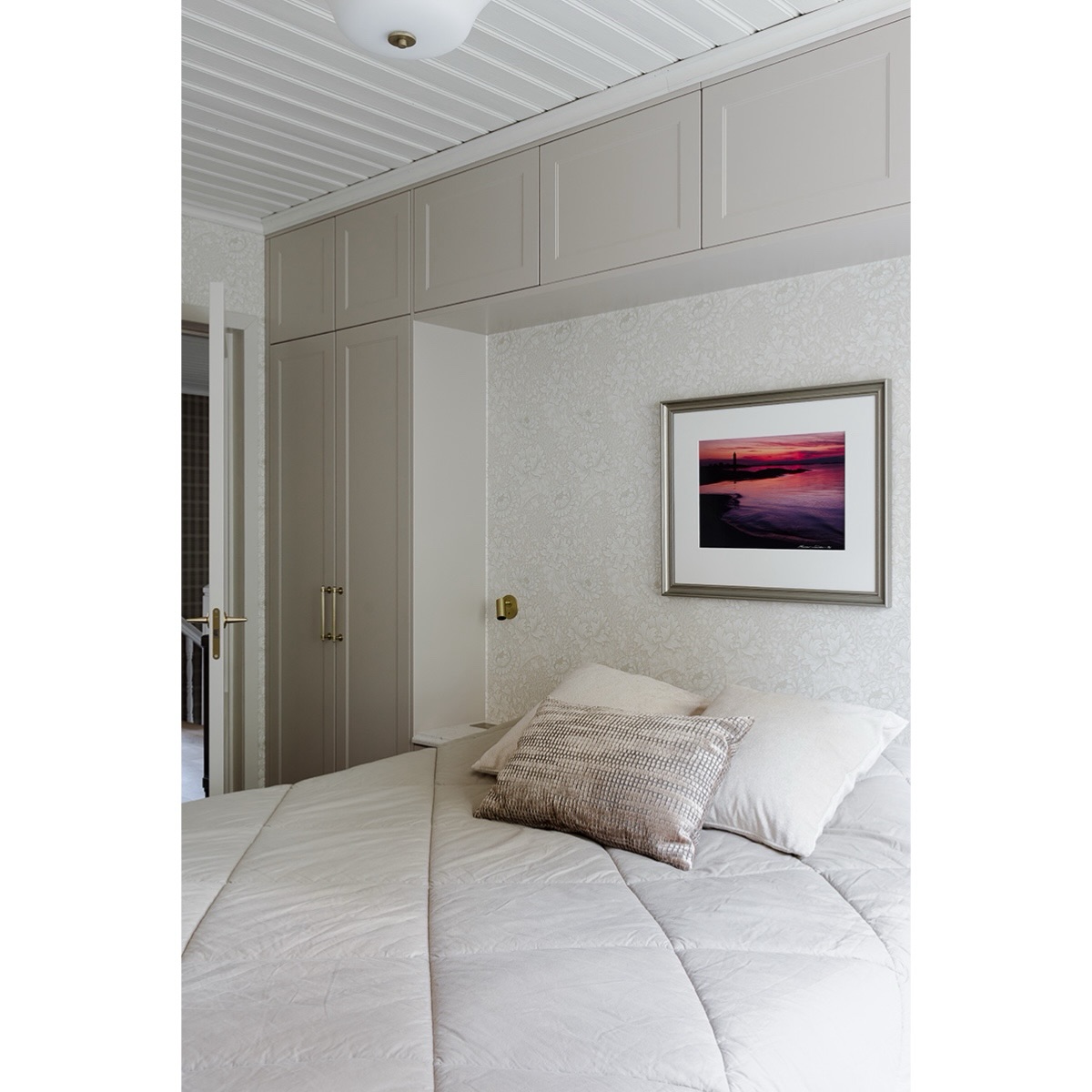 Metsän kätköissä – vaalea vierashuone 💫
Vierashuoneet haluttiin sisustaa toisiaan tasapainottaviksi, mutta selkeästi erilaisiksi. Näin vieraille on helppo sanoa: ottakaa te se vaalea huone.
Tämä huone oli kokonaisuudessa se, jonka tapettia jouduin etsimään pisimpään, puuttuva palanen kokonaisuudesta. Halusin, että makuuhuoneiden tapetit puhuvat samaa kieltä, ja siksi päädyin käyttämään kaikissa William Morrisin kuoseja. Yhteinen nimittäjä luo rauhallisen ja tasapainoisen kokonaisuuden, vaikka jokainen huone on luonteeltaan omanlaisensa.
Tästä huoneesta tuli erityisen sievä ja herkkä. Messinkikehyksinen antiikkipeili ja sen alla oleva antiikkilipasto tuovat tilaan kerroksellisuutta ja syvyyttä. Sängyn ympärille rakennettiin säilytystilaa sekä pienet, sirot yöpöydät integroiduilla pistorasioilla.
Yöpöytien yläpuolelle sijoitettiin pienet lukuvalot, joiden kapea valokiila mahdollistaa lukemisen rauhassa ilman, että vierustoveri häiriintyy valosta.
Jokaisessa makuuhuoneessa on meriaiheiset valokuvateokset, jotka ovat kulkeneet pitkään omistajien mukana ja ovat heille erityisen rakkaita. Aluksi pohdin, miten teokset saisi osaksi uudistunutta sisustusta luontevasti, mutta uusien kehysten myötä ne sulautuvat kokonaisuuteen kauniisti. On ilo, että muistot saivat jatkaa mukana, vaikka talo koki kokonaisvaltaisen uudistuksen.
Kaapisto @ainakeittiothyvinkaa
#sisustussuunnittelu
#metsankatkoissa
#designmood