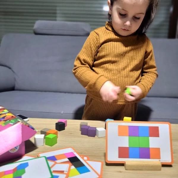 Smart Cubes comes with 20 wooden cubes / 10 different colours, 20 double-sided cards (40 tasks), 1 wood card holder. The patterns on the orange side of the task cards can be achieved by placing the cubes on the card; the patterns on the turquoise side of the task cards can be designed 3D. Our cubes are made of pure natural wood, are non-toxic and tasteless, contain no harmful substances, can be recycled and are very environmentally friendly. The surface of the cubes is smooth, without barbs, and children can use it safely. The corners of the cubes and the task cards are all rounded, without any points or sharp edges.
It can be played independently or in a small group taking turns. Smart Cubes can support learning individually as well as learning how to take turns, cooperate, and share.
Each cube is 2.4cmx2.4cmx2.4cm.
