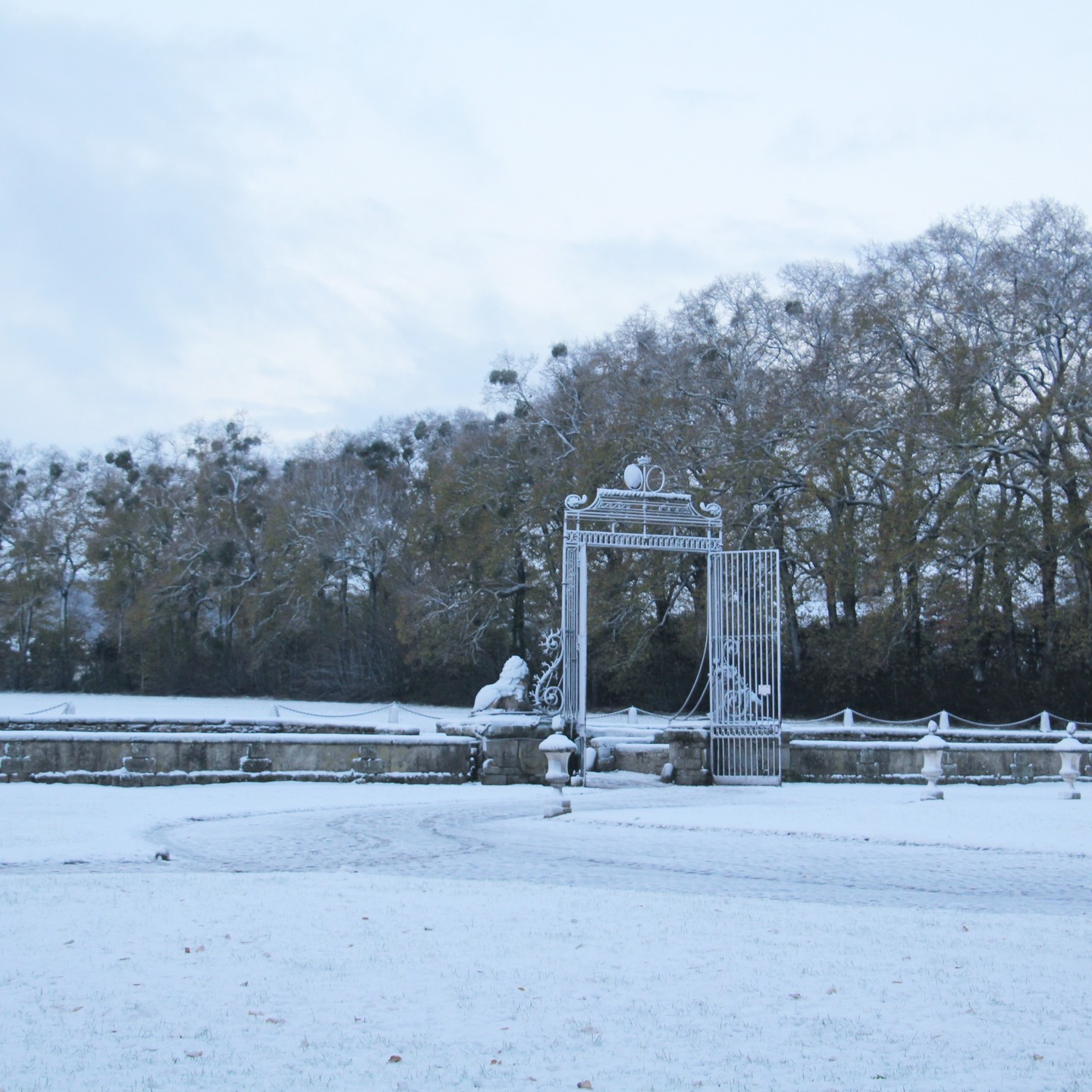 La cour d'honneur et son portail aux lions pendant les dernières neiges.