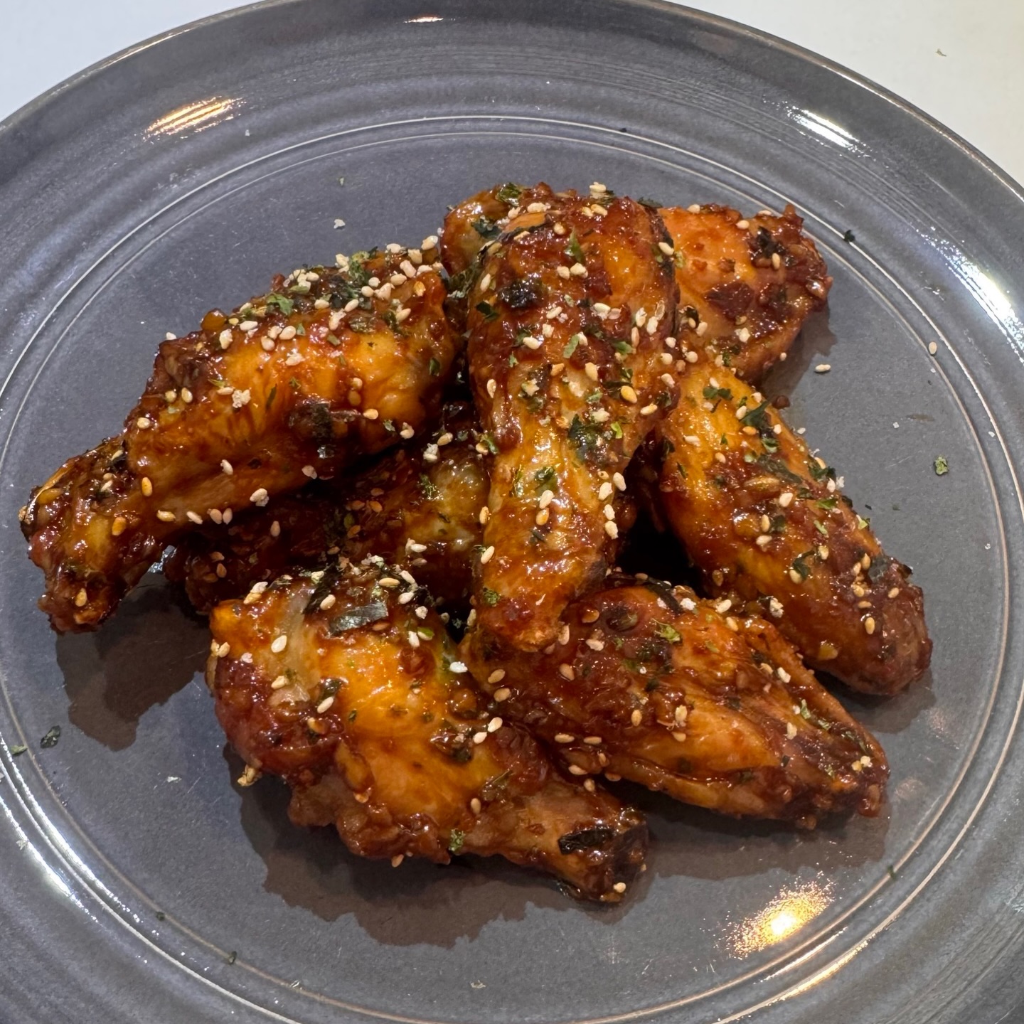 Umami Miso Honey Chicken Wings 🍗
INGREDIENTS:
Wings:
* 2lbs chicken wings
* 1 ½ teaspoon kosher salt
* 2 teaspoons baking powder
Umami Miso Honey Sauce:
* 2TBS Umami @garlikipaste
* 2 teaspoons pureed ginger
* ⅓ cup reduced sodium soy sauce or tamari
* ¼ cup mellow white miso
* 2 tablespoons honey
* 2 tablespoons sweet thai chile sauce
* 1 teaspoon sambal olek, chile garlic sauce or sriracha
Garnish:
* toasted sesame seeds
* minced scallions
INSTRUCTIONS:
Wings:
1. Line baking sheet with aluminum foil and set a wire rack inside. Dry the chicken wings with paper towels.
2. In a large bowl, combine the wings with baking powder and salt and toss until thoroughly and evenly coated. Place on the rack, leaving space between each wing.
3. Place the baking sheet in the refrigerator, uncovered, for at least an hour or up to 24 hours. This time resting in the salt brine will keep the wings juicy, tender and well seasoned. It also dries the skin which helps it to get crispy in the oven.
4. Adjust oven rack to upper-middle position and preheat oven to 450°F. Place the chicken wings in the oven and cook for 20 minutes. Flip and continue to cook until crisp and golden brown, about 15 to 30 minutes longer.
Umami Miso Honey Sauce:
1. Place all ingredients in a small saucepan and simmer on a very low flame until it has a thick and syrupy consistency, about 3-5 minutes. Stir occasionally. Be careful not to walk about from this sauce, as honey will burn quickly and easily.
Serve:
1. Toss wings in the sauce making sure they are well coated and serve sprinkled with toasted sesame seeds and minced scallion.