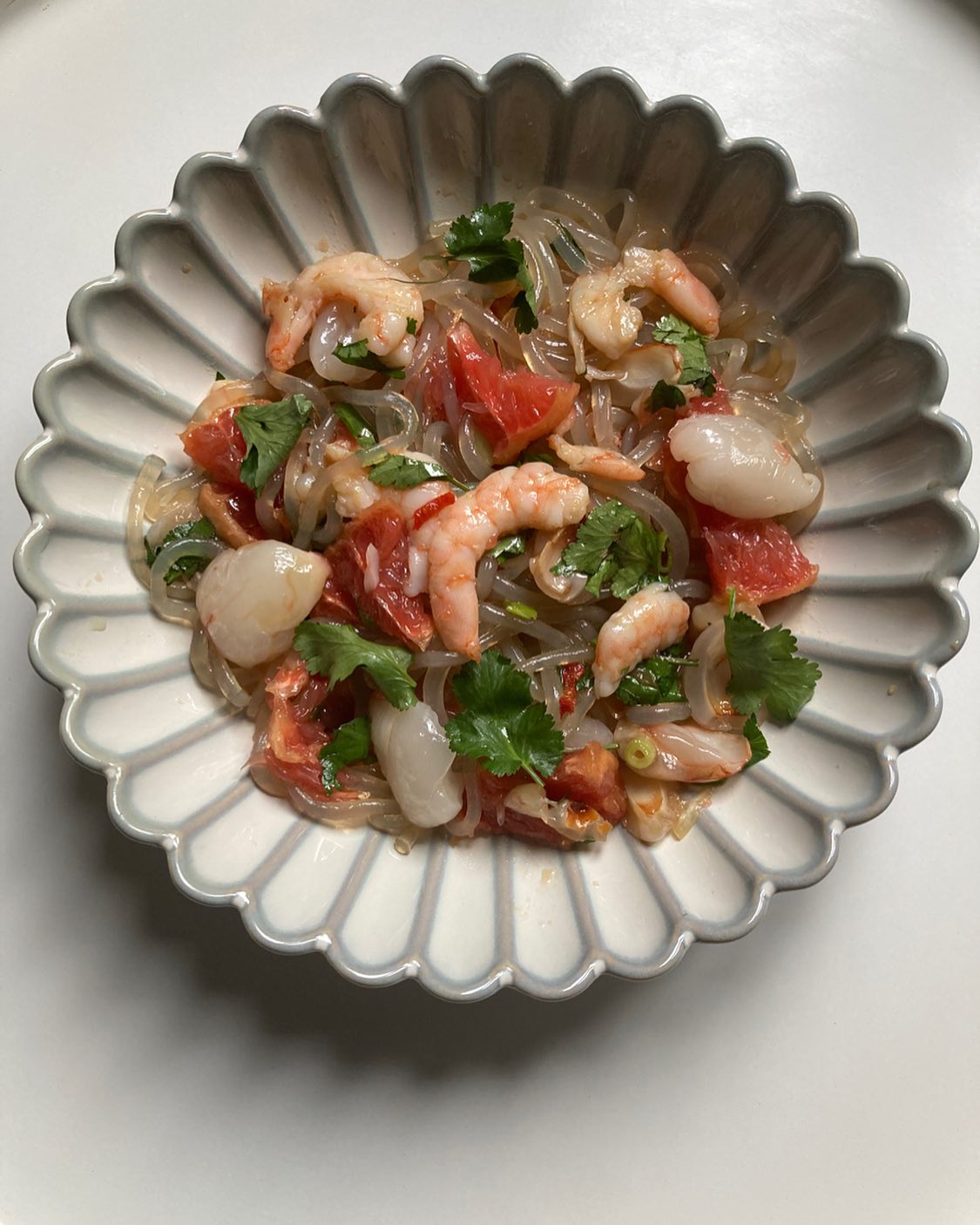 Salade thaï aux litchis, pamplemousse et crevettes!
OK! Il fait quand même bien froid encore pour une salade de crudités, mais celle-ci est à la fois bien fraîche (avec l’acidité des fruits) mais aussi super bien relevée en piment et gingembre, histoire de bien réveiller nos papilles. Cette recette est inspirée d’une recette de @thesocialfood, je trouvais l’idée super d’utiliser les litchis et le pamplemousse dans une recette thaï, je me suis juste permise d’ajouter des vermicelles de patate douce, pour apporter une bonne céréale un peu translucide a cette recette!
Pour 2 personnes: 100g de vermicelles de patate douce, 12 litchis frais (sinon en boîte), 1/2 pamplemousse rose, 10 crevettes roses cuites, 1 piment oiseau, 1 ciboule chinoise, 1/2 c.a soupe de gingembre frais râpé, 4 branches de coriandre fraîche, sel, poivre
Pour la sauce: 1 c.à soupe de sauce nuocman et de sauce de soja, le jus d’1/2 citron vert, 2 c.à soupe d’huile neutre et 1 d’huile de sésame grillé.
Faire tremper les vermicelles de patate douce 10mn dans l’eau tiède. Les cuire 10mn a l’eau bouillante, les égoutter et les passer sous l’eau froide.
Éplucher les litchis, enlever les noyaux et les couper en 4. Éplucher le pamplemousse, lui enlever toutes ses peaux blanches, le couper en tranches puis en 6.
Mélanger tous les ingrédients de la sauce.
Dans un saladier, mettre les vermicelles, ajouter tous les ingrédients, ainsi que les feuilles de coriandre et le piment coupé finement (à doser seulement votre goût).
Ajouter la sauce. Bien mélanger.
NB: Encore mieux de préparer cette salade 1 heure avant pour laisser les ingrédients bien infusés. On mettra alors quelques feuilles fraîches de coriandre au dernier moment.
Possible aussi de rajouter quelques cacahuètes grillées et concassées en topping!
#saladethai #saladecomposee #saladeexotique #recettethai #saladefraicheur #litchis #litchi #pamplemousse #pomelos #piment #cuisinethai #madreperlamtc