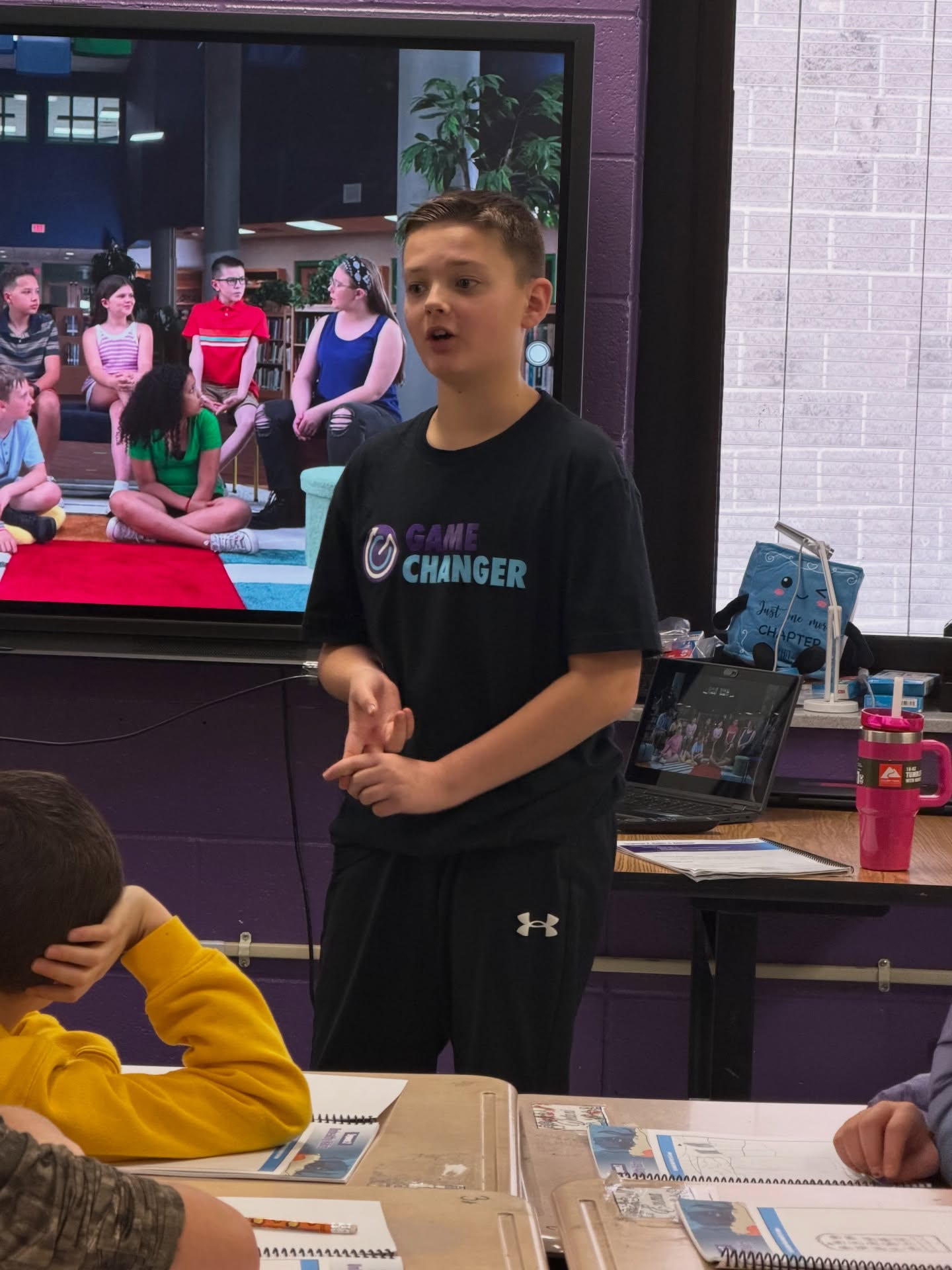 Clay Battelle Middle High School sixth grader, Grayson Mattingly, discusses the GameChanger film (playing in the background) with fellow GameChanger students. Grayson is the son of sixth year GameChanger coach, Nikki Mattingly.