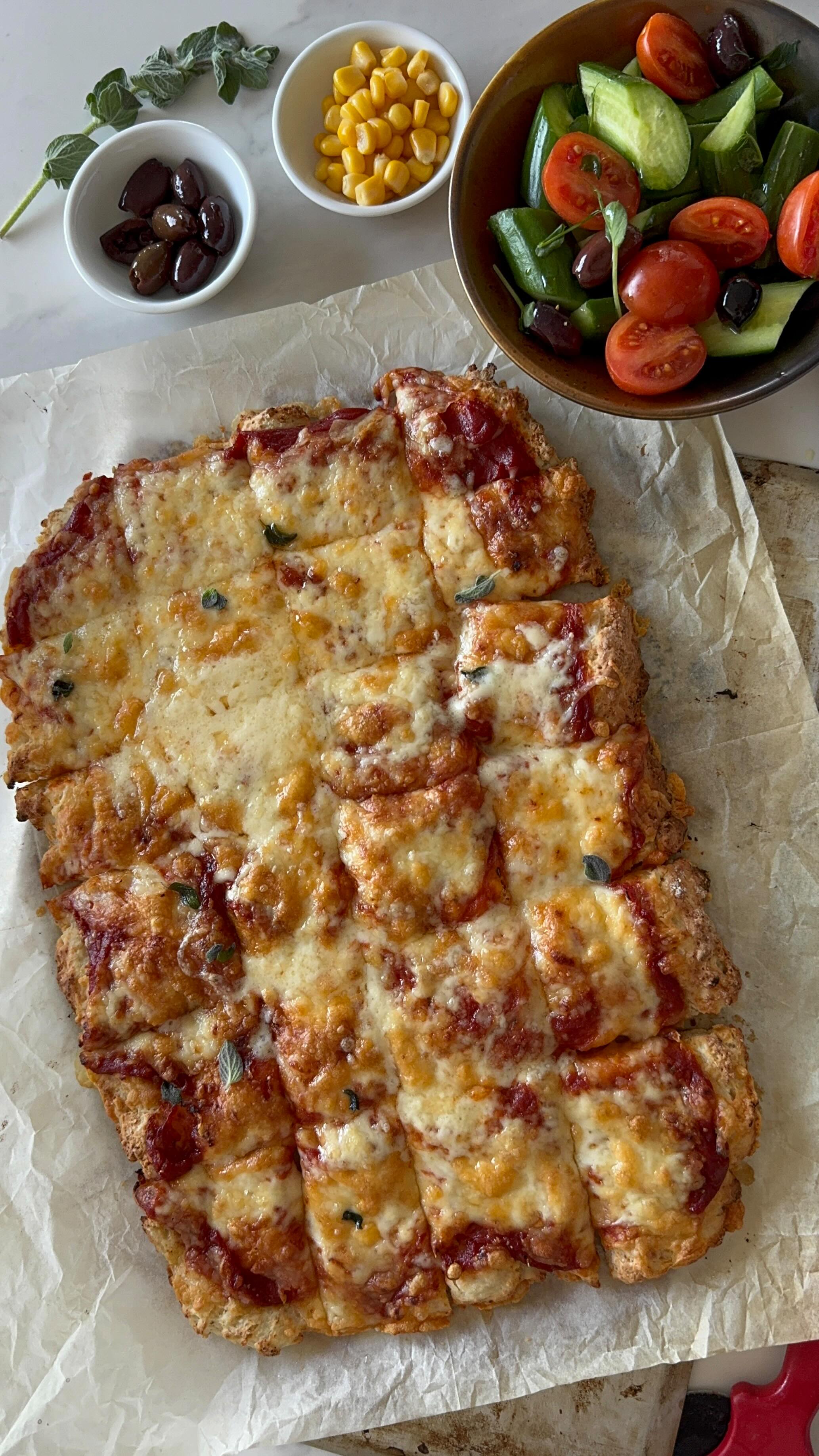  ריבועי פיצה מהירים ללא לישה
מושלם למוצש
קלים להכנה וטעימים
מבצק יוגורט עשיר רך ללא לישה.
החלפתי את השמן בבצק ביוגורט שנותן רכות ואווריריות ומזרז את התפחת הבצק.
מכינים בכמה דקות בקערה אחת בלבד
בלי מיקסר
משטחים במגש תנור
ואופים עד זהוב מושלם
ואז פורסים לריבועים קטנטנים וכיפיים
מושלם לארוחת ערב קלילה ומהירה לצד סלט טרי
מכינים יחד עם הילדים
ובוחרים את התוספות שכל אחד אוהב.
לבצק:
כוס וחצי קמח (225 גרם)
200 גרם יוגורט יווני דנונה
כפית אבקת אפייה
כפית מלח
1 כף סוכר
כפית שמרים יבשים
1 כף שמן זית
2 כפות חלב או מים
לרוטב:
150 גרם רסק עגבניות
כפית תבלין שום גבישי
כפית אורגנו
מלח,פלפל.
כפית סוכר
כפית שמן זית
לגבינה:
200 גרם גבינה מגוררת (או לפני הטעם)
תוספות שאוהבים:
תירס/זיתים/פטריות
אופן ההכנה:
מחממים תנור ל220 מעלות.
אופים את הפיצה בתחתית התבנית (השלב הנמוך בתנור כדי שתחתית הפיצה תאפה היטב)
בקערה מערבבים את כל חומרי הבצק לשים לבצק אחיד ודביק (אין צורך במיקסר)
מכסים ומניחים בצד לחצי שעה מנוחה.
על גבי נייר אפיה משטחים את הבצק מורחים רוטב וגבינה,
אופים במשך 15-20 דקות עד שהתחתית אפויה והגבינה מבעבעת.
בשיתוף דנונה