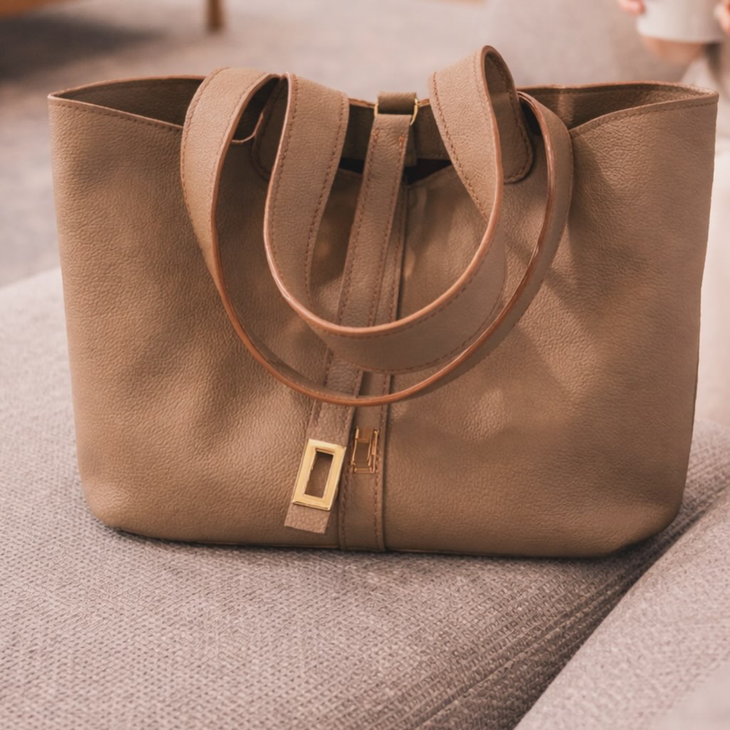 Sac Thelma en cuir de vachette grainé, doublure tissu, poche intérieure zippée. Fermeture par bride.