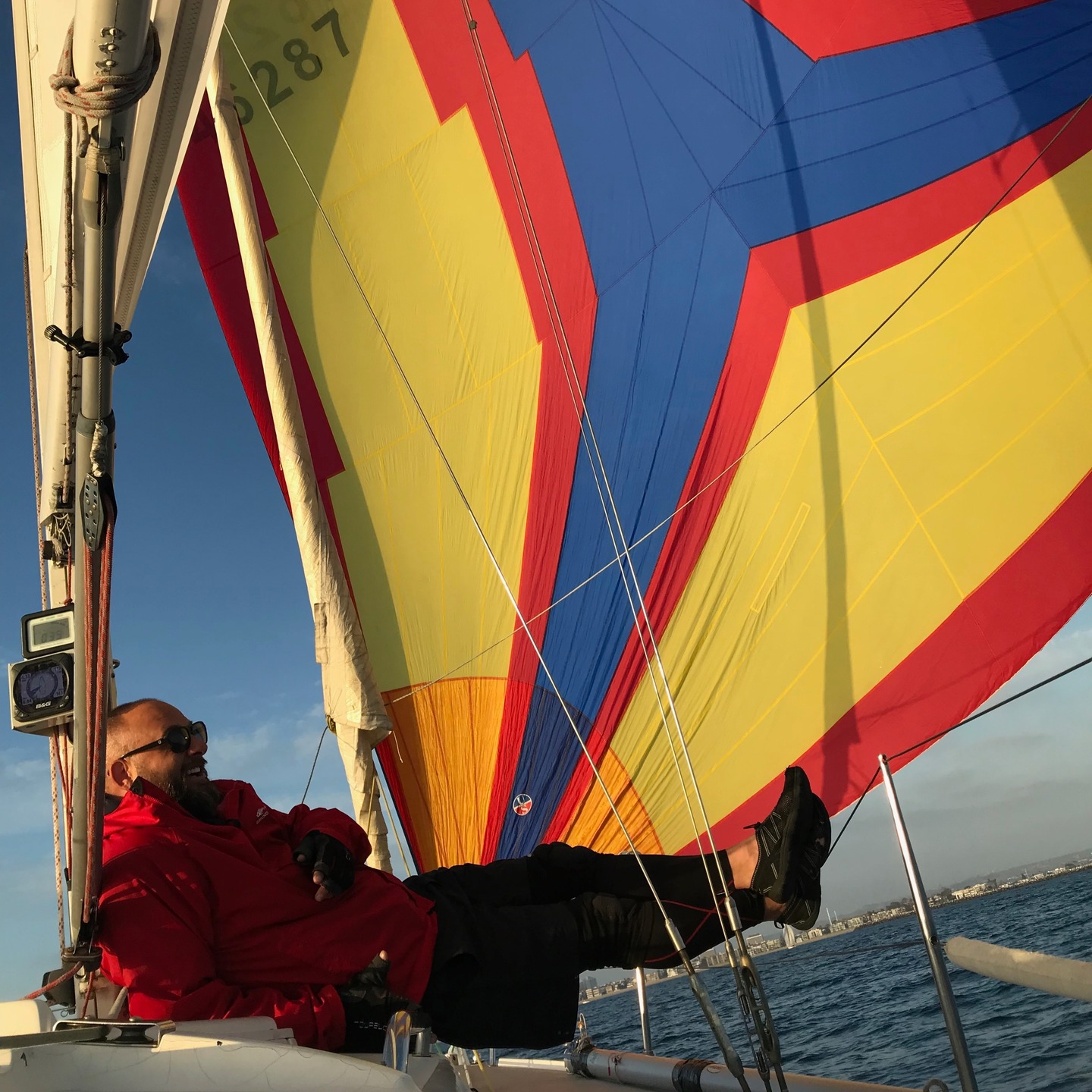 Captain’s Log: Race to Learn
Yesterday someone asked me how I learned to sail. Short answer? Mild emotional collapse + sunlight deficiency + a J/105 named 12 Bar Blues.
There was a season of my life where I was basically a cave creature living in an edit bay, 19 hours a day, surviving on fluorescent light and bad decisions. I needed a change before I fully evolved into a nocturnal film goblin. So I signed up for ASA 101 and 103. Day one on the boat I thought, Oh. This is it. This is the thing for the rest of my life!
My instructor — racing zealot, lovable lunatic — said, “If you want to learn to sail, you go racing.” Translation: throw yourself into chaos and hang on. He got me on a J/105 called 12 Bar Blues. Captain Chuck at the helm — eternal student, old salt, part philosopher, part mad scientist — along with four core crewmates: one guy on the main who had practically memorized the boat’s manual, three absolute killer female sailors who quietly ran the universe with precision, a couple other novices like myself, and from race to race, other different folks — all of them lovely, motivated and awesome to be around.
We raced every Tuesday and Wednesday in Southern California. I started as rail meat. Human ballast. Decorative hiking furniture. Then moved to jib. Then clawed my way to the foredeck — which is basically CrossFit while being slapped by laundry in a hurricane. Tall guy? Congratulations. You now live at the pointy end where sails try to assassinate you politely.
On the boat, we flew an asym and a Code Zero, but more importantly than the type of sail, it taught me how to hoist, run, and douse these monster sails. No snuffer, no top-down furler — run the tapes, bag launch it, bring it back down the hatch, and send it again multiple times. It made me very comfortable working with big sails out in weather. Invaluable for what I am doing now. Racing teaches you how hard you can push — and what happens when you push too far — both invaluable lessons for offshore sailing.
Racing didn’t just teach me how to sail. It gave me sunlight. It gave me people. It gave confidence to sail alone.
Days Sober: 2,249