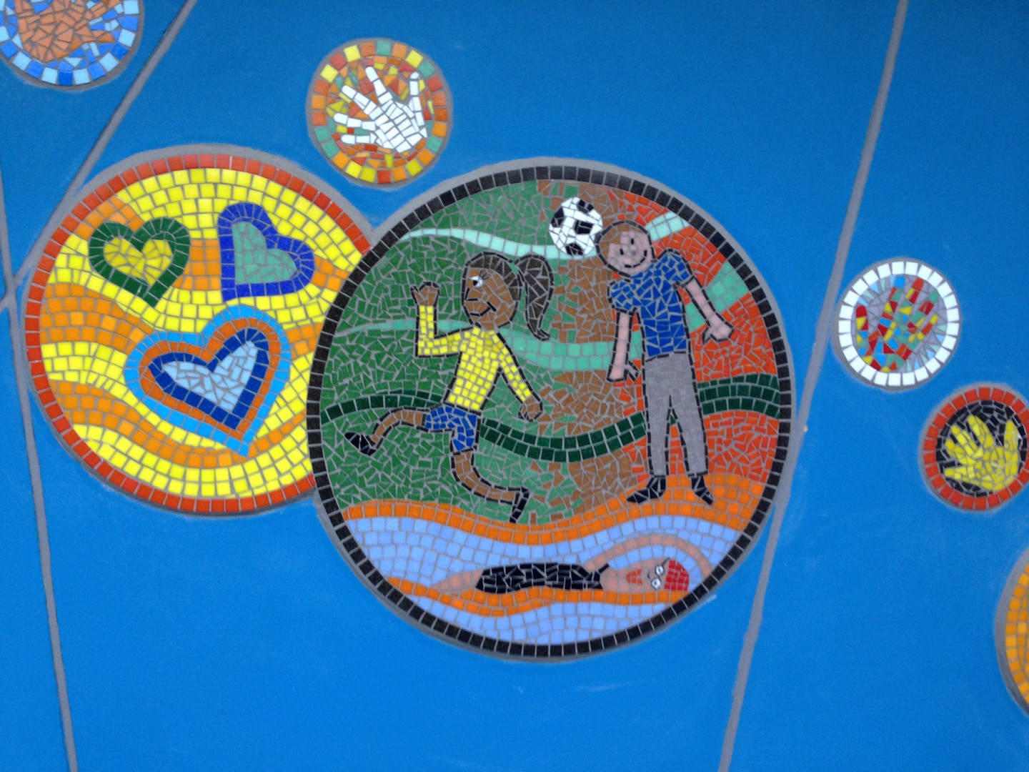 When you have a large area to cover mosaics are a fantastic way to do it. This blue wall was vast but by adding these mosaics in relief on the wall we added lots of colour and shapes to create a welcoming entrance for Rayleigh Primary School. The designs all reflect the rights of a child.
#exteriordesign #mosaicart #mosaicsforschools #handprints #primaryschool #primaryschoolart #rightsofachild #themosaicstudio #colourfulartwork #hugemural