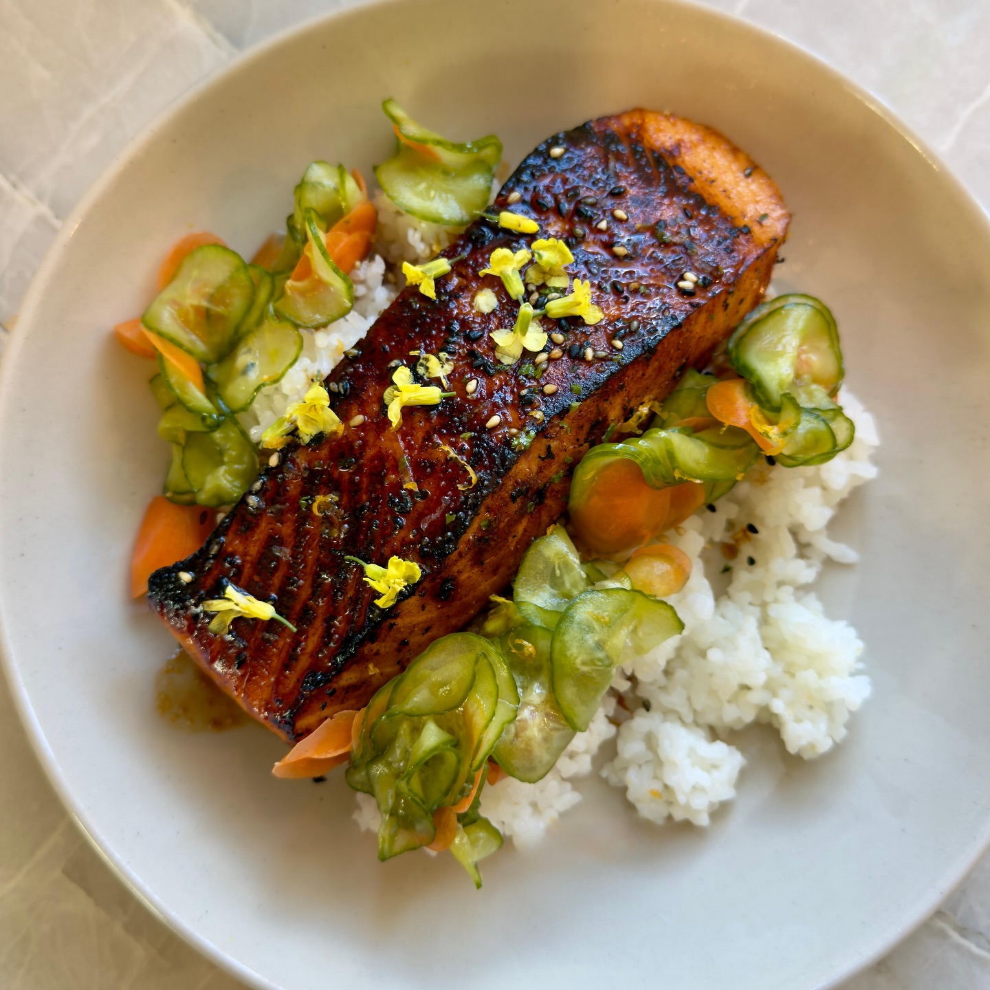 Private chef plates, Entry 03: @orakingsalmon is the wagyu of the sea.
So when I’m asked to do teriyaki, I keep a light hand to lift the fish, not drown it.
Salmon + rice • Cucumber carrot pickles • Mustard green flowers • House made furikake
#privatechef #orakingsalmon #teriyakisalmon #lunchplate