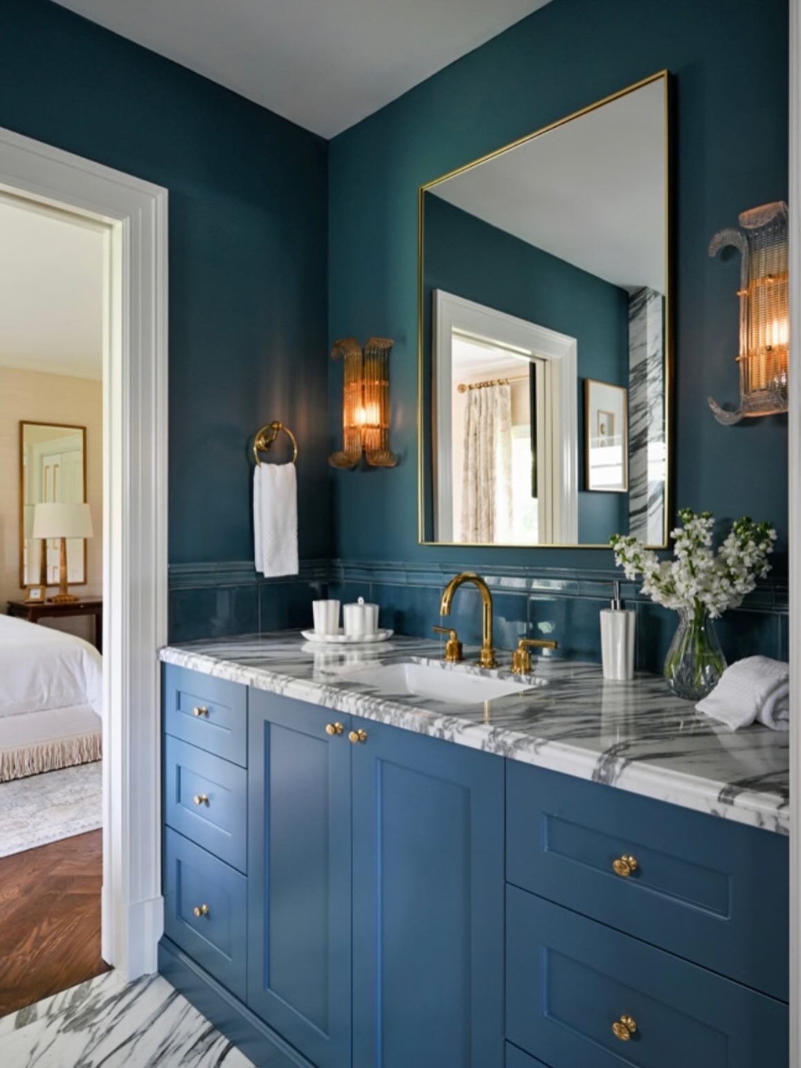 Another room from the same project! We wrapped this bathroom in a blue @waterworks tile wainscot and painted the walls and trim to match. These @hudsonvalleylighting sconces have also stolen our hearts.