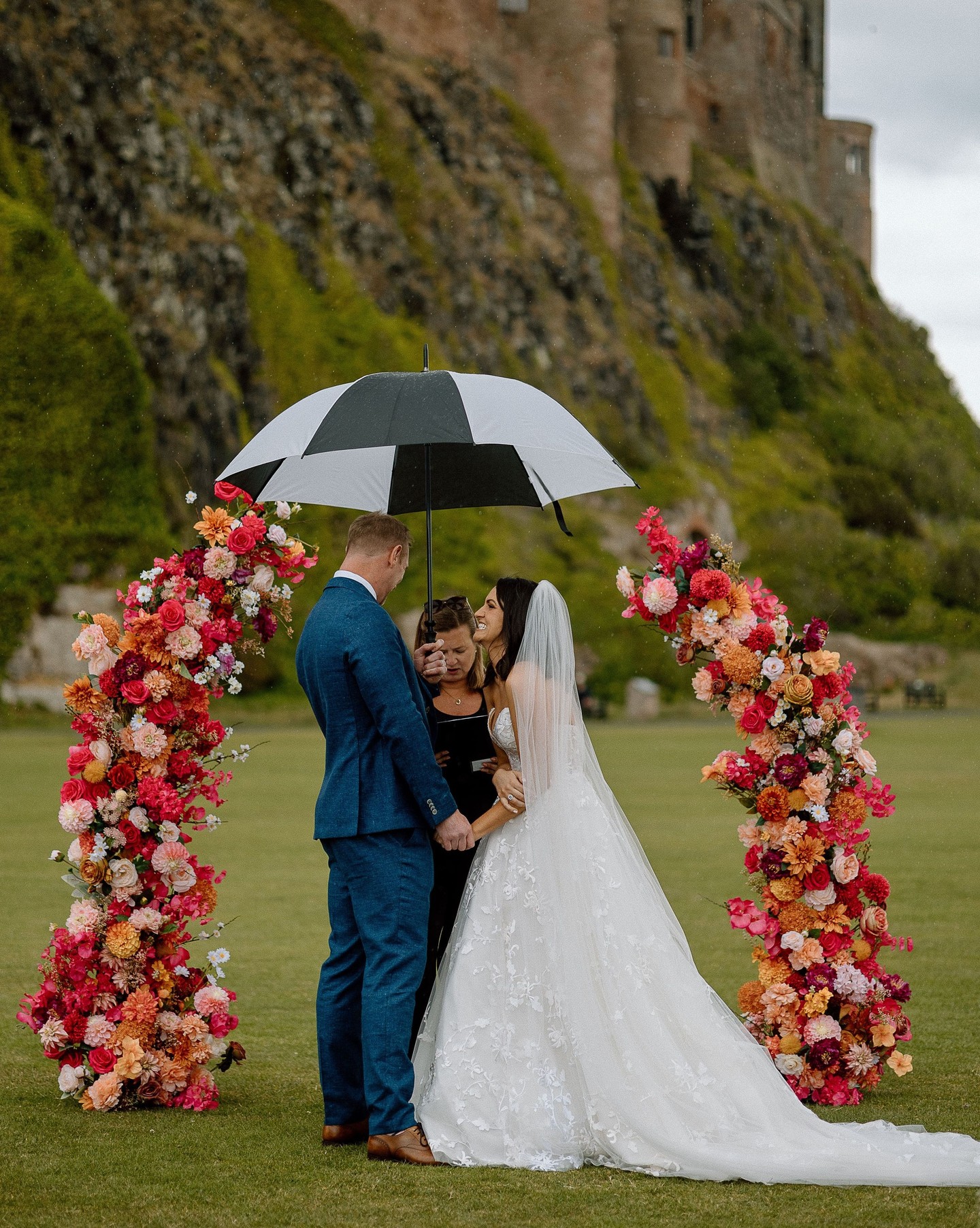 Proof that you need to embrace the things you can't control!
Rosie & Henry's laughter filled, albeit rainy day, really is the perfect example to not let things going wrong ruin your day, but to instead make the most of it and have a great time!
What to do instead? Grab an umbrella and have the biggest smile on your face all day, which is exactly what R&H did! The vibes were absolute perfection, from the ceremony in front of Bamburgh castle with a statement colourful floral archway to the live music and oysters for canapés, these two really knew how to party and if anything the rain made for stunning photos and a great story! ☔️
Plus rain on your wedding day is good luck so maybe we should all wish for it? 🤞
📸: @helenrussellphotography