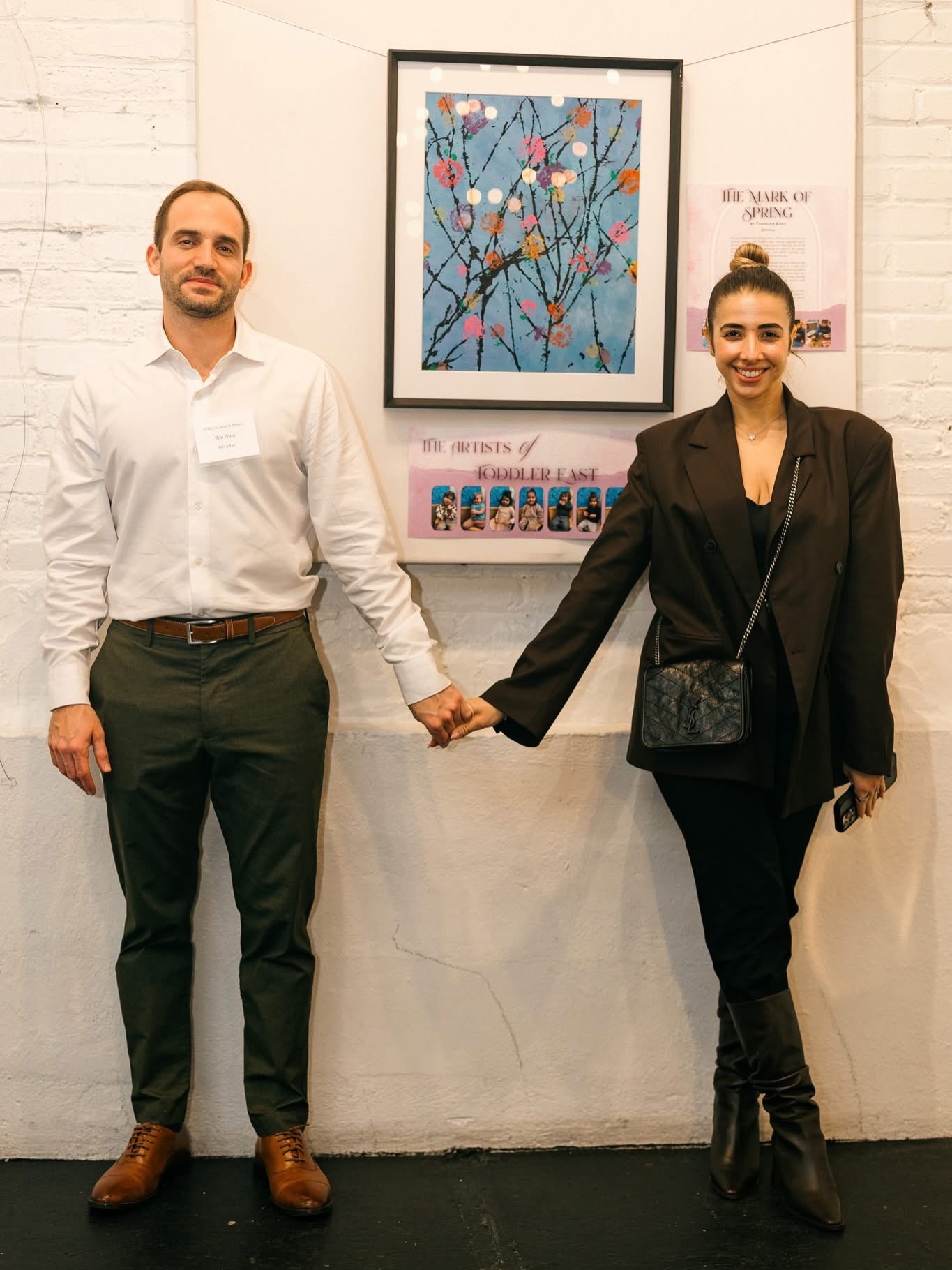 Congratulations to the Amir Family ❤️ #POTAArtAuction
Toddler East: The Mark of Spring
For our collaborative spring and Tu B’Shvat art-inspired art auction project, the Toddler East friends explored color, texture, and movement using natural materials found all around us. We began by painting the base of the canvas with different shades of blue and white, layering and blending the colors together to create the sky.
Then, during a walk, friends searched for and collected big sticks and tree branches, gathering them in a pile and bringing their discoveries back inside. We dipped our found branches into a tray of black paint, raised them over our heads, and smacked them down onto the canvas, leaving behind expressive, tree-like marks full of motion and energy.
Lastly, we used real flowers to add the finishing touches and complete the piece. Friends picked a flower, dipped it into paint, and used it as a stamp to add delicate, floral patterns on every branch.