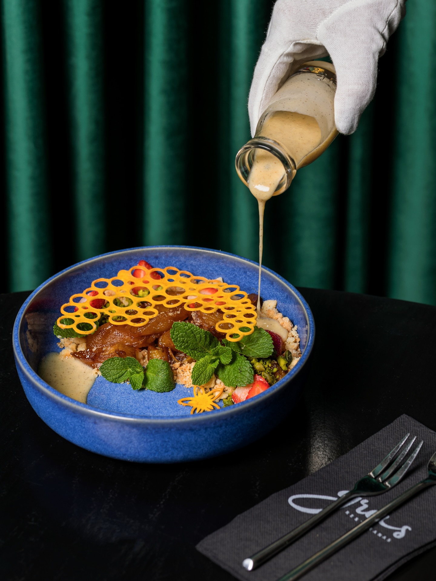 Obuolių pyrago destrukcija – lyg pažįstamas vaikystės jaukumas, pritaikytas šiuolaikinio skonio potyriams.
✨ Braškių gaiva ir lengva rūgštelė subtiliai subalansuoja atpažįstamą obuolių ir cinamono šilumą, o sviestinis trupinys įneša trapumo ir švelniai riešutinį biskvito prisilietimą. Šis derinys sujungiamas aksominiu vaniliniu padažu, kuris apgaubia ir palieka šilkinį finalą. Tuomet prasideda tekstūrų teatras: traška – tirpsta – teka, išlaikydamas subtilų saldumo ir rūgšties, šilumos ir gaivos balansą, kurio taip nesinori paleisti.