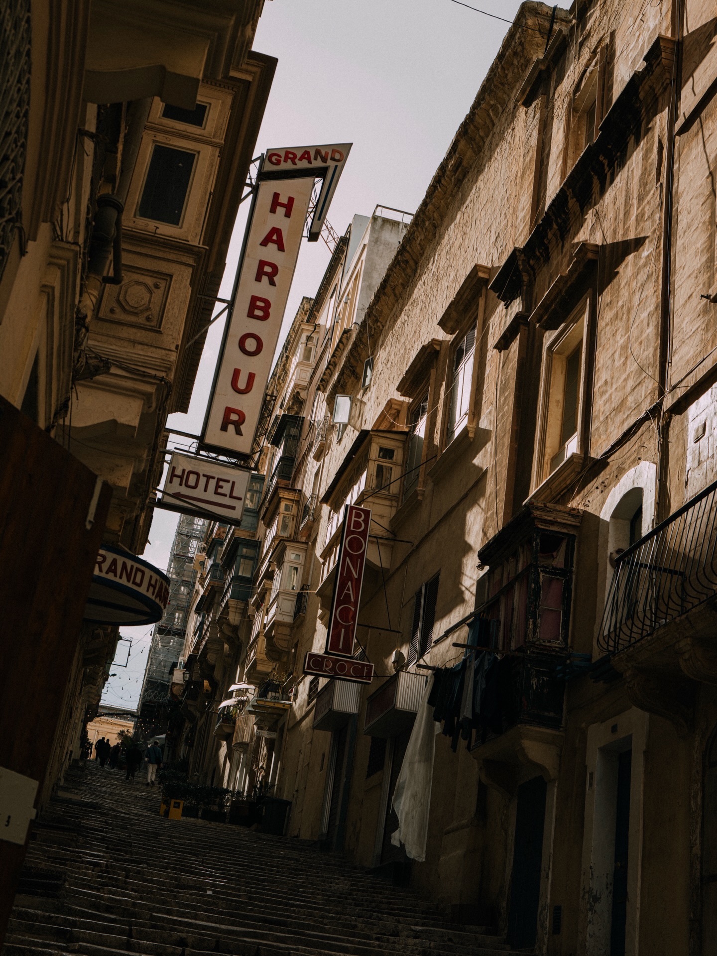 In Valletta’s golden maze I roam,
where light and stone softly converse
and down St. Ursula Street, joy blooms
in every echo of my footsteps.