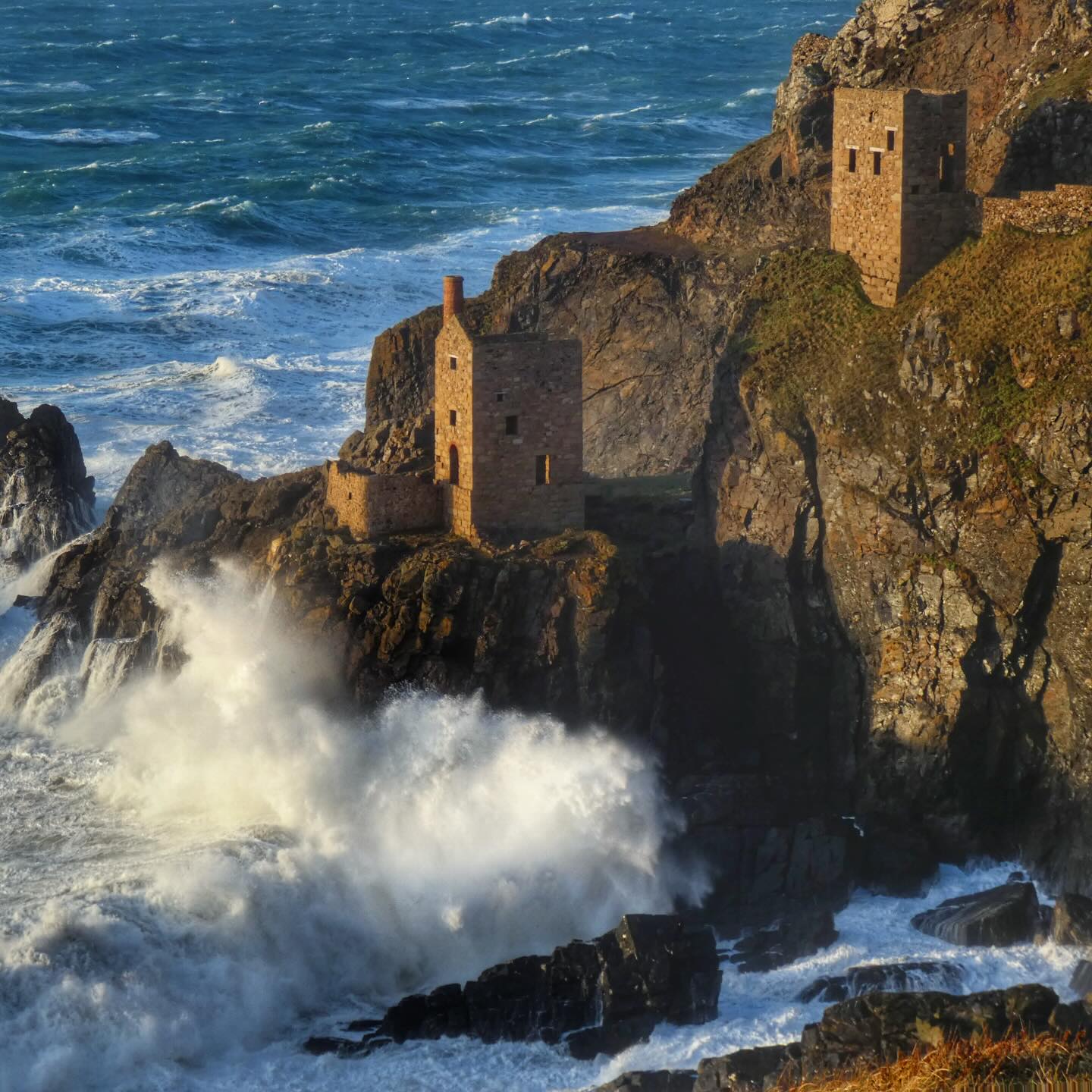 Looking forward to a sunny Valentine’s Day Geowalk down to Botallack this Saturday!
A bit of info just to remind you what these spectacular buildings are all about.
Why build something on the side of a cliff exposed to the full force of the Atlantic?! Well, the wealth of Earth’s resources that lie beneath has led to these engineering marvels.
The Crowns engine houses were built in the mid 19th century, the lower housed a 30” pumping engine and the upper a 24” winding engine that powered the skips on rails up and down Boscawen diagonal shaft.
It might be hard to envisage today without the tons of timber framework that has since been removed, but the portal to the inclined shaft is visible in the cliffs just above high water.
Boscawen diagonal shaft was sunk at a 1 in 3 gradient, and the mine extends a kilometre out under the sea. Engine Shaft, used for pumping from the lower engine house, is 135 fathoms (or 250 m) straight down. The lowest levels of the mine are 250 fathoms (460 m) below sea level.
The Crowns isn’t just Cornish mining royalty, the site has been visited by actual royalty in the past. The Prince of Wales (future King Edward VII) visited in 1865 and descended the Boscawen diagonal shaft.
This was two years after a fatal accident at the mine, where 8 men and a boy were killed when the winding chain snapped, plummeting the skip to the bottom of the shaft.
Thankfully these engine houses were consolidated by the Carn Brea Mining Society in the 1980s, and are conserved by the @tincoastnt to allow visitors to enjoy this spectacular site.
It’s a geologist’s playground here, and I could spend hours exploring the cliffs, spoil tips and archaeology.
There are still spaces on the Geowalk available if you want to come and learn more. Follow the link below or click on the link in the bio for the Cornwall Geowalks page.
https://www.cornwallgeologist.co.uk/event-details-registration/tin-coast-guided-geowalk-half-day-saturday-14th-february-2026
#botallack #cornishmining #tincoast #cornwall #cornishcoast