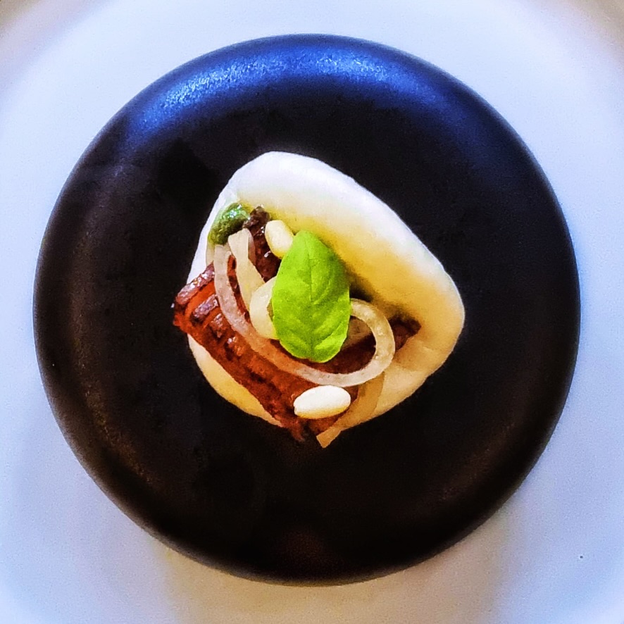 The overture to the “Mare ε Monte” menu takes its first inspiration from the Valpolicella hills of Veneto: scored and crisped honey-kissed pancetta affumicata is paired with a pine nut crema, picked shallots, brandy-steeped raisins, and basil.
In a marriage that is at once one of convenience and yet also one of true love, the bride is from Fujian where steamed buns pursed around honeyed-ham is much-loved for both flavour and the fact that there’s no danger of sticky fingers.
This bite-sized flavour bomb looks forward to awakening your tastebuds and getting you ready to take a dive into our menu that journeys between land and sea.