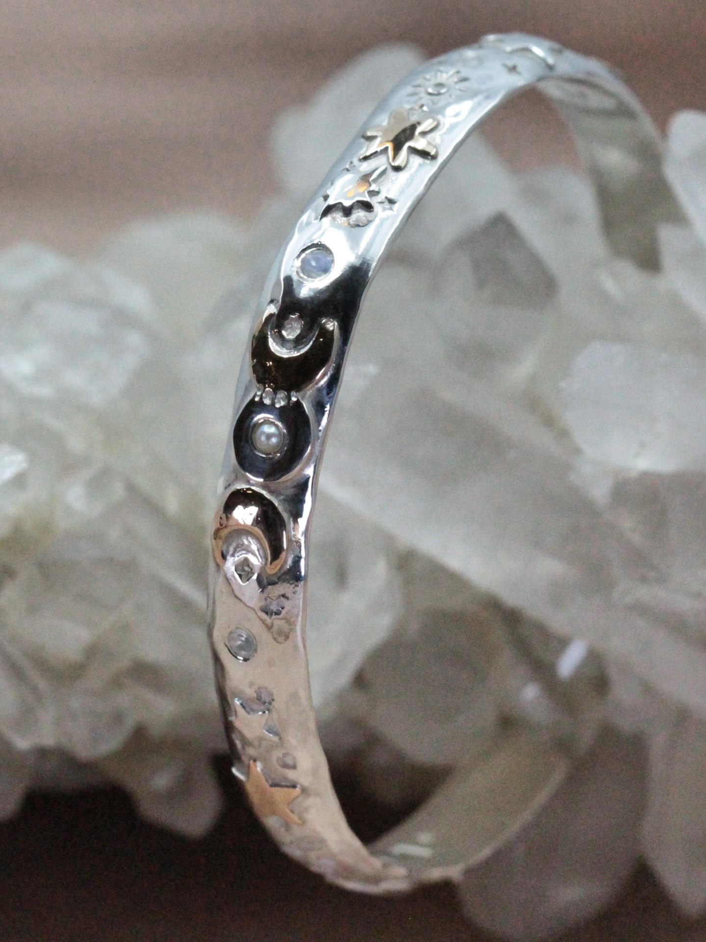 š Mystic Menace Cuff ā Lunar Lady Edition š
Created in honour of lunar cycles, divine feminine power, and the balance of light and shadow ā the Lunar Lady is a wearable moon ritual.
āļøOne of a kindāļø.
At its centre sits the Triple Goddess ā Maiden, Mother, Crone ā with one golden crescent touching the central full moon, subtly honouring the Horned God and the sacred rhythm between masculine and feminine energies.
The crescents are crafted in 12k gold fill, framing a sterling silver full moon set with a luminous freshwater pearl, while rainbow moonstones shimmer either side ā flashing with intuition and lunar magic.
Across the band, celestial motifs of stars, Polaris, crescents, heart and starburst scatter like constellations across the night sky.
Stamped into the cuff are powerful guardians:
⨠Triskelion ā cycles & forward motion
⨠Evil Eye ā protection
⨠Hamsa ā blessing & shielding
⨠Lightning Bolt ā personal power
⨠Sun ā vitality & power
⨠Goddess ā divine feminine intuition
š Gemstone Energy
Freshwater Pearl ā wisdom & emotional sovereignty
Rainbow Moonstone ā intuition, new beginnings & spiritual connection
A one-of-a-kind talisman for the woman who honours her cycles, trusts her intuition, and walks her path in both light and shadow. For a 6.5" wrist.
Available in to see in the studio and online now āØļø
#MysticMenace #LunarLady #CelestialJewellery #TripleGoddess #MoonstoneMagic