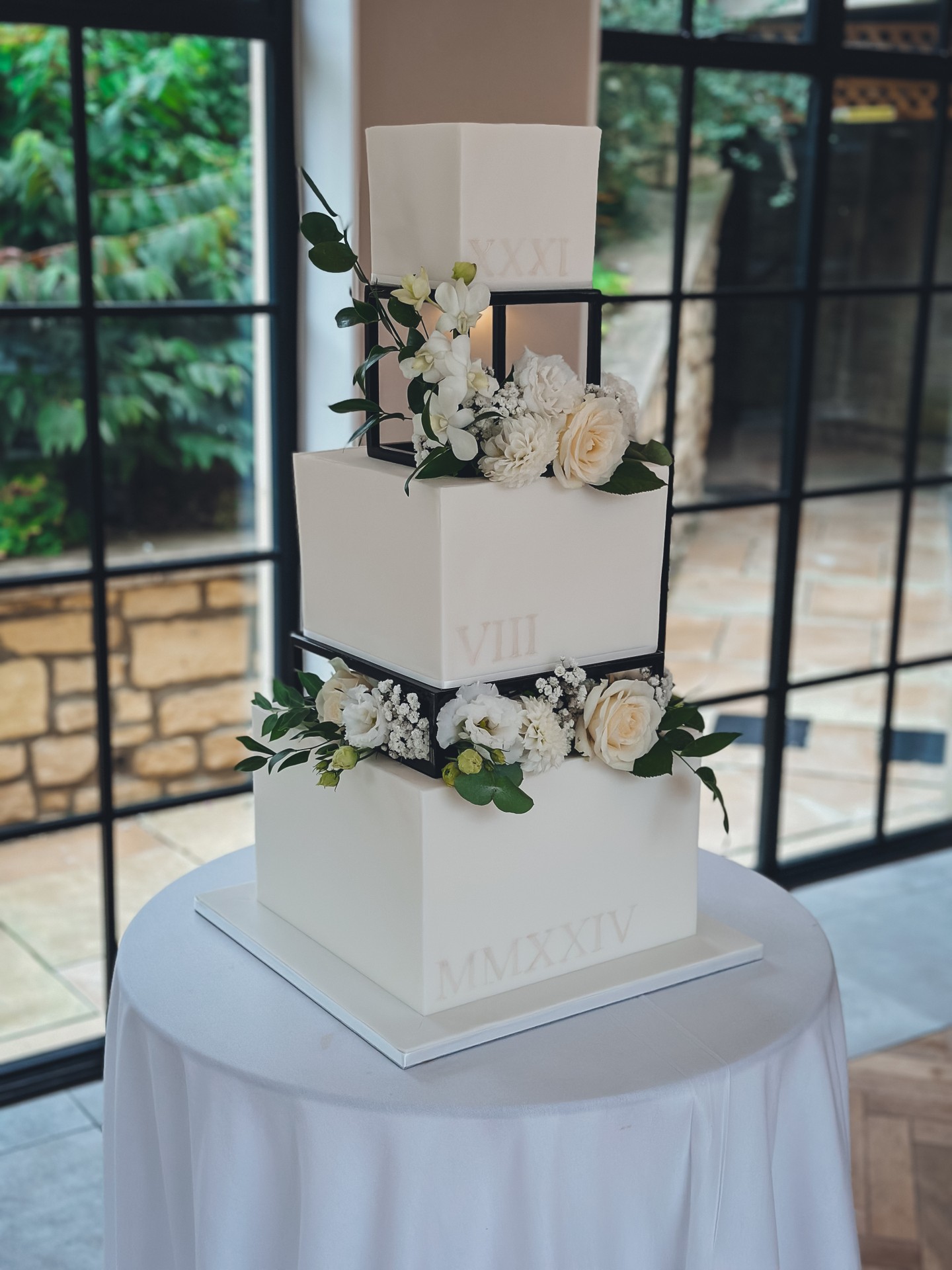 Structure. Balance. Intentional contrast. 🤍
A three tier square design finished in flawless ivory fondant, elevated with black detailing and soft white florals. Clean lines softened by natural movement.
The Roman numerals add subtle storytelling without overpowering the design. A quiet nod to significance.
The black frames introduce depth and dimension, giving this cake a modern architectural feel while the florals keep it romantic and refined. 🌿✨
This is for couples who appreciate simplicity done properly.
No excess. No noise. Just considered design from every angle.
If your wedding aesthetic leans modern, minimal and elegant, this style works beautifully within contemporary venues.
View the portfolio:
https://www.kimberlyjaynecakedesign.co.uk/portfolio
Enquire via the website to check availability 🤍
#LuxuryWeddingCake #ModernWeddingCake #SquareWeddingCake #ArchitecturalCake #ElegantWeddingDesign