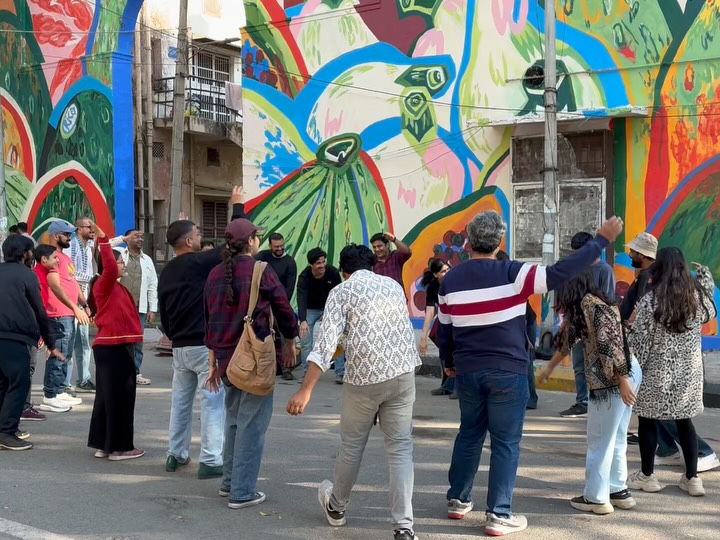 On Sunday, Kaivalya Plays had the privilege of presenting a public improv theatre intervention as part of Lodhi Art Festival 2026, curated by St+art India Foundation, at the Lodhi Art District. 🎨🌿
We arrived early and chose to conduct our improv warm-up in the open street rather than out of sight.
People paused.
They watched.
We invited them in.
The warm-up evolved into a facilitated improv jam. By the time our in-house ensemble, The Sunday Plan, began the formal performance set, nearly 40 people had participated in or gathered around a live, unscripted theatre experience. 🎭
What made this possible was structure, not chance:
A clear safety frame.
A shared agreement.
Take care of yourself.
Take care of your scene partner.
Take care of the space.
Within that framework, complete strangers felt comfortable improvising together in a public setting.
On a rare, luminous Delhi afternoon ☀️, surrounded by murals and the artists on the walls 🎨, improv became a civic practice. Open, accessible, participatory.
We are grateful to the organisers for creating space where theatre can move beyond conventional venues and into shared public life.
This is what structured improvisation can unlock.
Trust. Agency. Collective presence. 🤝✨
#ImprovTheatre #PublicArt #DelhiImprov #DilateAllArtSpaces #CommunityEngagement