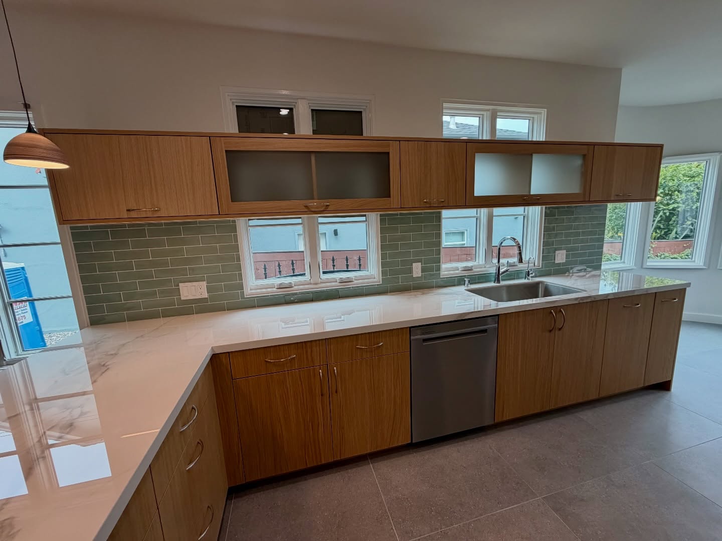 Natural light was the priority here.
A continuous row of windows along the backsplash brings daylight directly onto the countertops, while upper clerestory windows add brightness without sacrificing cabinet space.
Clean, modern, and intentionally bright.