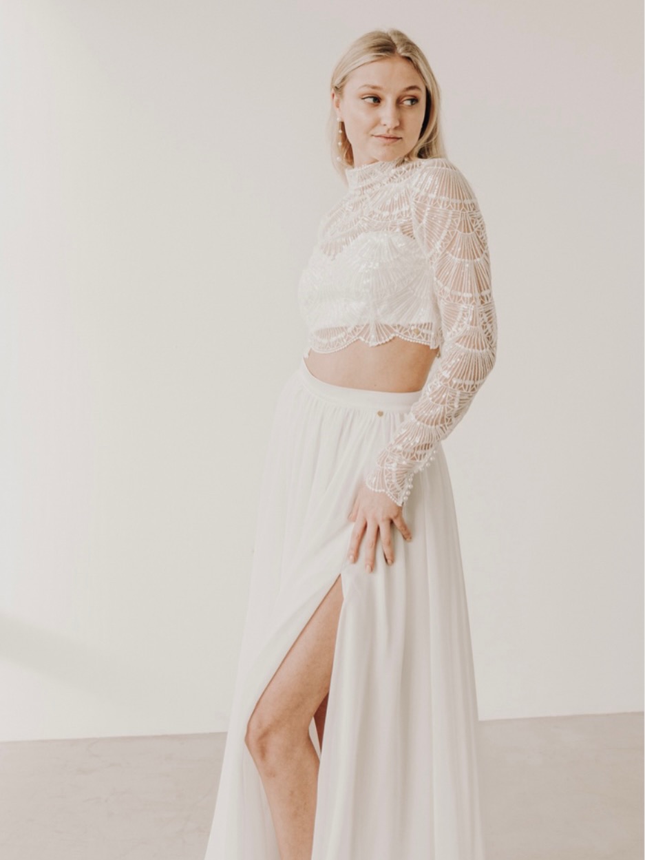 Statement statt Tradition 🤍
Ein zweiteiliges Ensemble, das Leichtigkeit und Selbstbewusstsein vereint:
Das filigrane, hochgeschlossene Spitzen-Top mit geometrischem Muster wirkt edel und gleichzeitig außergewöhnlich. Die langen, transparenten Ärmel verleihen dem Look eine elegante Raffinesse, während der dezente Crop-Schnitt einen modernen, mutigen Akzent setzt.
Der fließende Rock mit hohem Beinschlitz bringt Bewegung ins Gesamtbild und sorgt für eine feminine, kraftvolle Silhouette. Weich fallender Stoff trifft auf klare Linien – minimalistisch und doch ausdrucksstark.
Ein Look für Bräute, die:
✨ Individualität lieben
✨ Moderne Eleganz suchen
✨ Und an ihrem großen Tag ein Fashion-Statement setzen möchten
Perfekt für das Standesamt, eine urbane Hochzeit oder als Second Look für die Party am Abend 🤍
#wedding #hochzeit #braut #bridetobe #modernbride