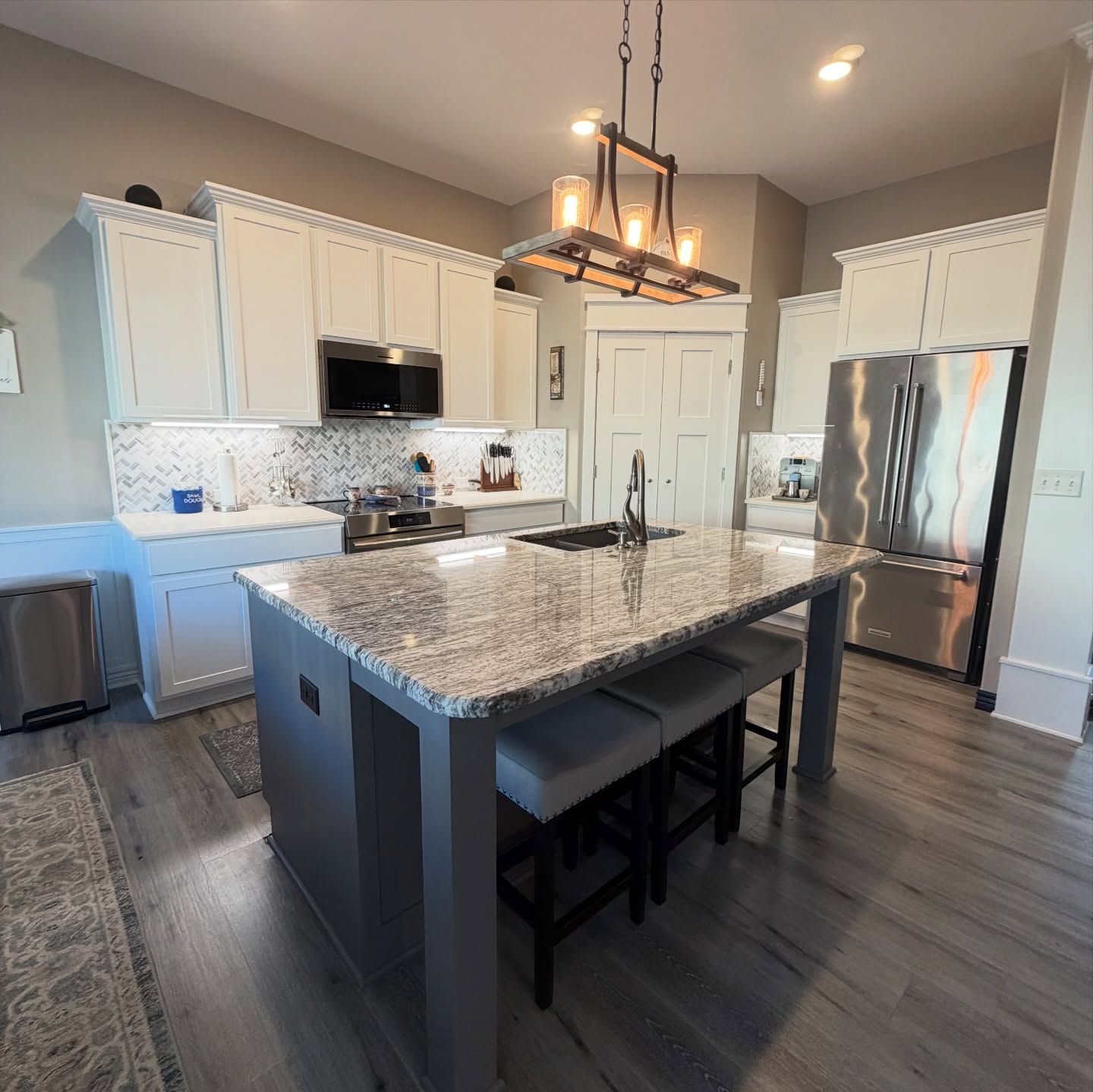 When we first saw these (check the before pics at the end 👀), the previous finish was super streaky and uneven — and way darker than the homeowner wanted.
So we switched things up ✨
We brightened the perimeter with Pure White and refinished the island in Gauntlet Gray to tie in beautifully with the backsplash, counters, and flooring.
Now it feels cohesive, balanced, and so much lighter. Proof that the right color combo (and proper prep + technique) makes all the difference.