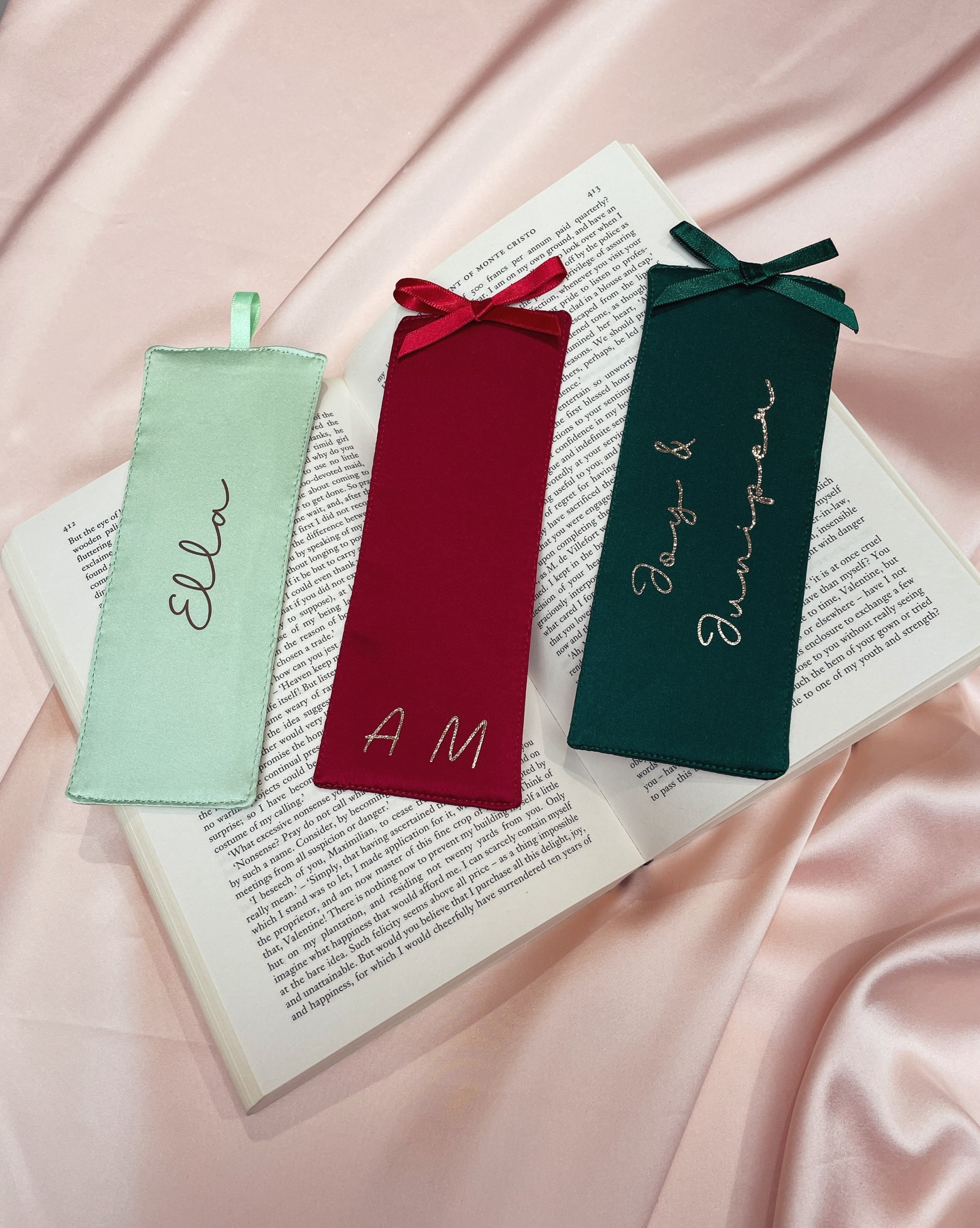 A few examples of how my new silk bookmarks can also be personalised with heat transfer foil vinyl- I have sampled a few examples to show you!
These classic silk bookmarks are the perfect for gifts for bookworms, students, teachers and graduates or as a little treat for your own book collection and personalisation just makes it even more special to give
Image description- 1. Three silk bookmarks in mint green, deep red and deep green laid out in a row on top of an open book. The mint green bookmark has the name Ella added in foil vinyl, the deep red has A M added in vinyl and the deep green has Joy & Juniper added in vinyl
2. The mint green bookmark laid out on an open book
3. The deep red bookmark laid out on an open book
4. The deep green bookmark laid out on an open book