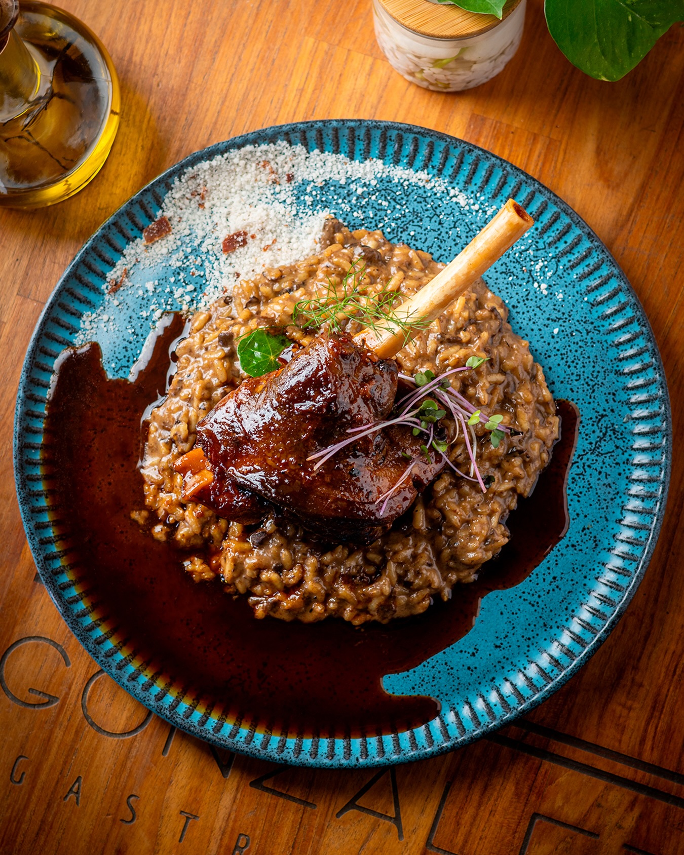 Stinco de cordeiro ao vinho, maciez que se desfaz. Com risoto de funghi, puro requinte à mesa.