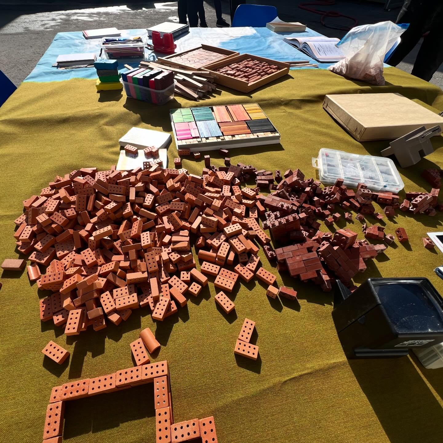 DISPLACEMENT AND PATIENCE IN CALAIS
February 25th 2026
Today in Calais everyone experienced the most beautiful, unseasonal Spring weather, with bright blue skies and warm air. From the Calais beach, the White Cliffs of Dover appeared on the horizon as if only an arm’s length away. This was the first calm weather in two weeks which means that people will inevitably be taking the immense risks of trying to cross in small boats to the UK.
The freshly painted day centre @calais.exilessc was laid out expectantly with hundreds of charging points, and the place was busy with preparation to greet people displaced in the Calais area, mostly young unaccompanied young men from Sudan. A large group from Lille prepared Ramadan food packages for the breaking of fast this evening.
We set up The Community Table outside in the strong sunshine, having been moved from the main space inside. Initially the sun was too bright, the placement too close to the football, so for the second time we moved the table until it finally found its place in the shade.
Outside we could appreciate different perspectives, supported by the natural light. In contrast to the 3D images created by the ViewMasters which are for a single viewer, we noticed several young men enjoying looking at slides with ourselves and others through our pocket slide viewers, exclaiming at the vivid clarity of the images of birds, mountains and flowers.
We also noted the contrast between the continual movement of the adjacent football players passing the football to each other in a circle, and the small scale, quiet calm and gentle activity around the table. The afternoon gradually found its pace, a number of young people becoming immersed in what they were doing for a sustained period of time. Several small homes and structures were made with the miniature building materials.
As we know from many years of offering The Community Table in this setting, we have to have faith and patience that its rhythm will be found, and that those who need it most will find their way to it.
Miriam Usiskin and Bobby Lloyd
#psychosocialsupport #thecommunitytable #displacement #ramadan #togetherwithrefugees🧡