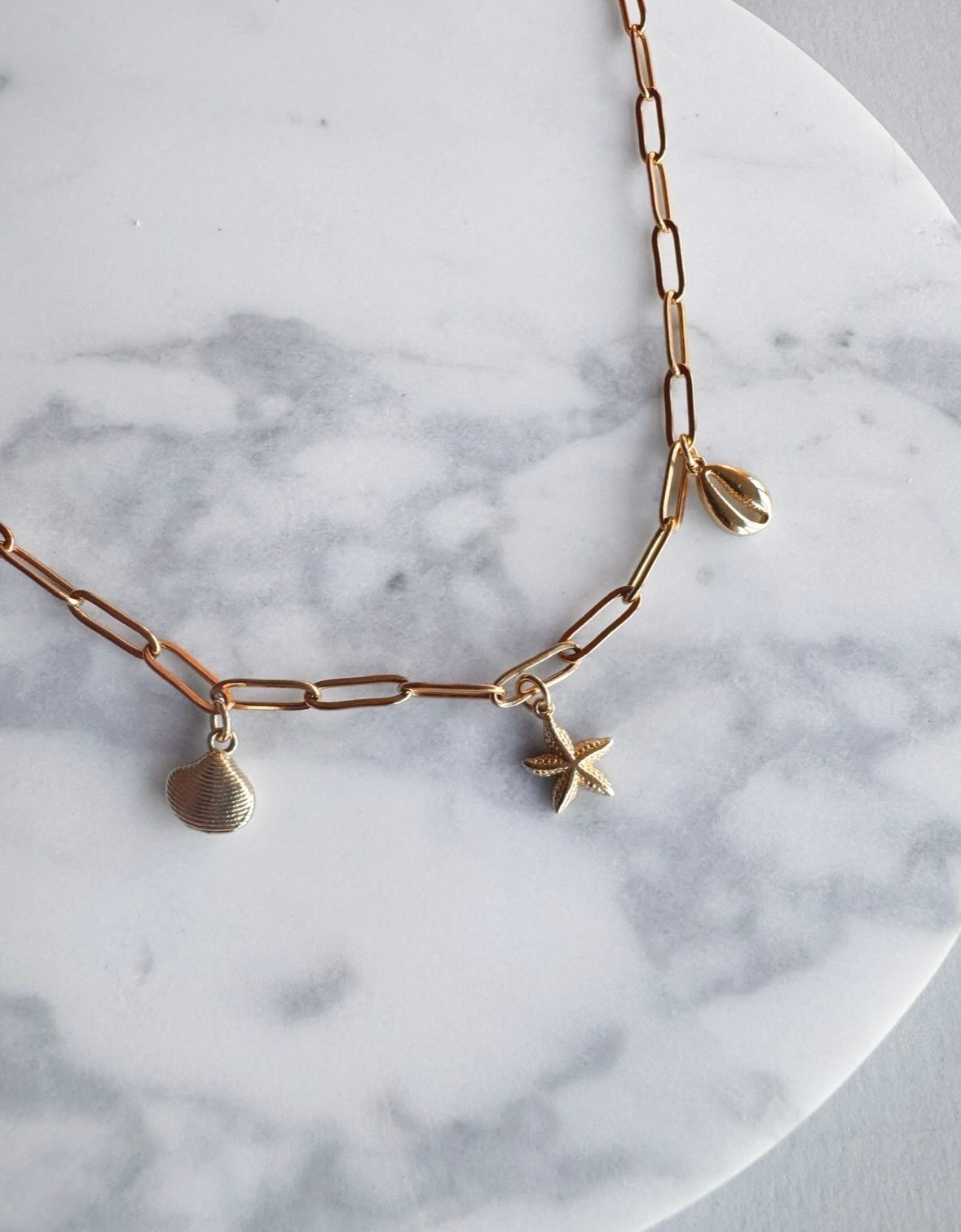 We love our Lani Charm Necklace 🥰 Seaside charms on a paper clip style chain, 18k gold on stainless steel, waterproof and tarnish free 🧜🏼♀️