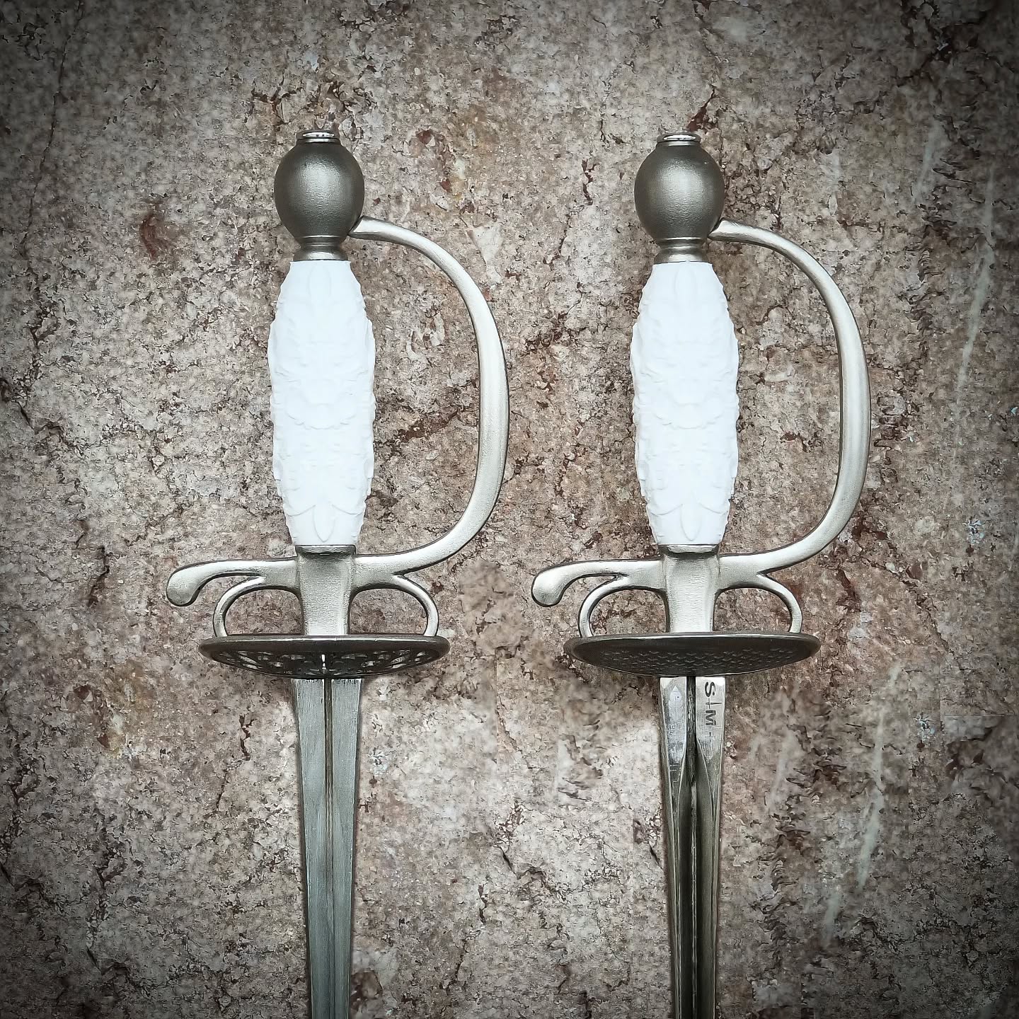The beloved model from 2021. is back with a small liftup ⚔️🤗♥️
The Smallsword Standard 2 continues the philosophy of the Standard Line by Feather Smallswords, offering an accessible yet refined weapon designed specifically for fencers.
This model is based on our legendary 2021 design of Model 2—one of the most recognizable pieces in our history. For the Standard 2, that original concept has been carefully redefined with improved finishing, greater precision in construction, and elevated overall quality while preserving the balance and character that made Model 2 so successful.
Created as an entry-level smallsword for fencers, the Standard 2 focuses on practical handling, durability, and clean aesthetics. The model is equipped with a knuckle bow, adding increased finger protection and confidence during training and sparring. This additional guard element enhances safety while maintaining the elegant lines of the hilt.
In this picture with No.5 Economy Epee blade, Decorated white grip
Sword length: 1035 mm (≈ 40 3/4 inches)
Sword weight: 445 g (≈ 15.7 oz)
Guard length: 160 mm (≈ 6 5/16 inches)
Blade length: 875 mm (≈ 34 7/16 inches)
Grip length: 82 mm (≈ 3 1/4 inches)
Ricasso length: 35 mm (≈ 1 3/8 inches)
Guard shell diameter: 84 × 70 mm (≈ 3 5/16 × 2 3/4 inches)
PoB (from guard): 90 mm (≈ 3 9/16 inches)
#Smallsword #Smallswordfencing #HEMA #HistoricalFencing #swords