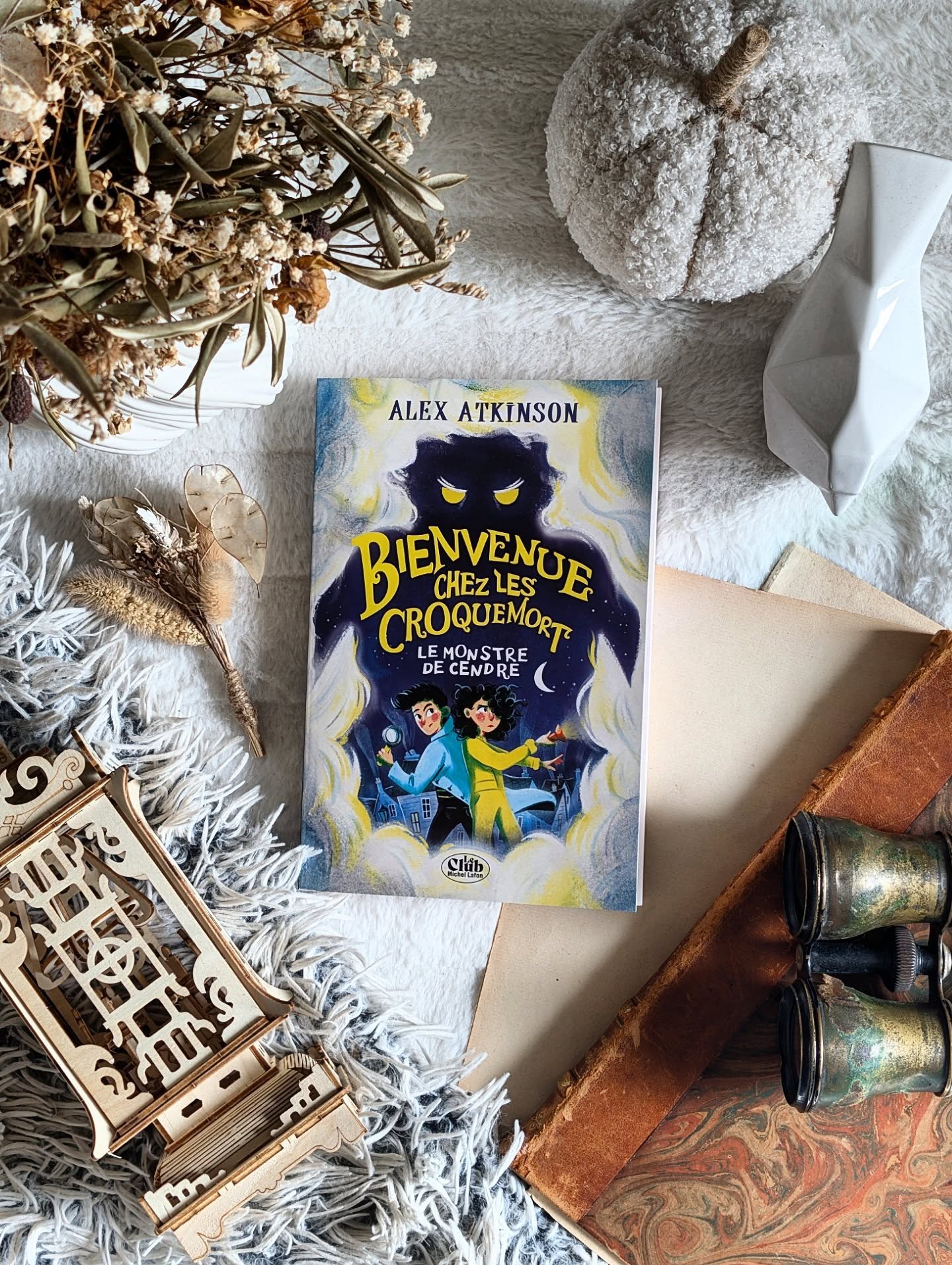 ✨ Bienvenue chez les Croquemort, Tome 1 : Le Monstre de cendre - Alex Atkinson ✨
Partons pour de la littérature jeunesse signée @michellafon_jeunesse !
À Griseroche, un esprit maléfique commence à prendre le contrôle des habitants. Ambiance. Indigo et Rusty Croquemort n’ont pas vraiment prévu de sauver la ville, mais ils n’ont pas tellement le choix. Problème : ils ne sont pas exactement sur la même longueur d’onde au départ… Et quand un monstre de cendre sème le chaos, il va falloir apprendre à coopérer, et vite.
J’ai adoré le cadre : ces deux-là vivent au milieu des cercueils et des corbillards, dans l’entreprise familiale. Autant dire que la mort, ils connaissent. Mais les fantômes ? Disons que c’est une autre histoire…
Ce roman fantastique jeunesse à une vibe « Chair de poule » et j'ai beaucoup aimé retrouver cette ambiance de ma jeunesse.
L’histoire se lit très bien, on à un rythme assez soutenu mais ça fonctionne. J'ai retrouvé des moments un peu angoissants pour nos héros et aussi de l'humour que j'aime tant avoir dans des romans jeunesse. J'ai vraiment aimé suivre leur quête à leurs côtés et voir la dynamique entre nos deux protagonistes.
Ça reste du jeunesse mais pour ma part j'aime la simplicité de ces romans, parce que même si l'intrigue est assez simple, la lecture reste fluide et accessible aux plus jeunes comme aux adultes.
En bref, une lecture douce avec ce petit côté frisson qui peut plaire à ceux qui recherchent à avoir peur mais pas trop ! Une belle surprise pour ma part.
Indigo et Rusty vous attendent, alors filez les rejoindre ☺️.
#BienvenueChezLesCroquemort #AlexAtkinson #LectureJeunesse #RomanJeunesse #Bookstagram
*Service presse @michellafon_jeunesse*