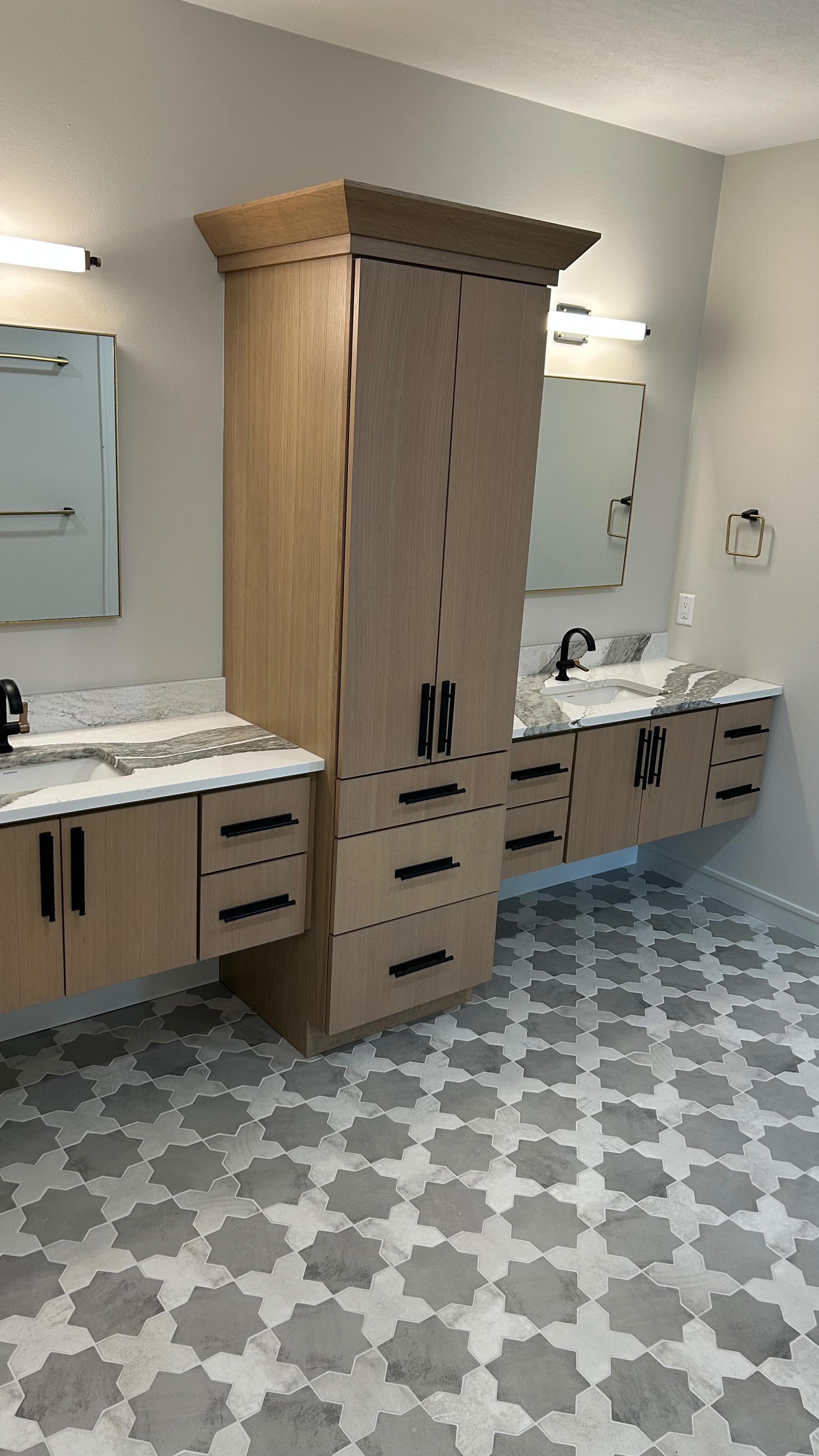These modern bathrooms have different vibes, but belong to the same home! We love the fun wallpaper in the guest bathroom and the storage tower separating the his & hers sinks in the main bath! If you’re looking for a fun way to punch up your home, a half bath is a great place to start small!