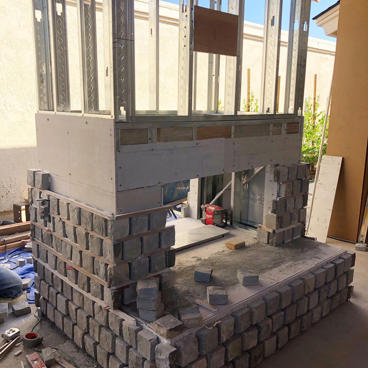 Cobbling in progress...can’t wait to see this California room fireplace complete with shiplap, a wooden mantle, and a television alcove. 👊🏻 #remodel #outdoorfireplace #suliso #oclandscape #orangecountyhomes #landscapedesign