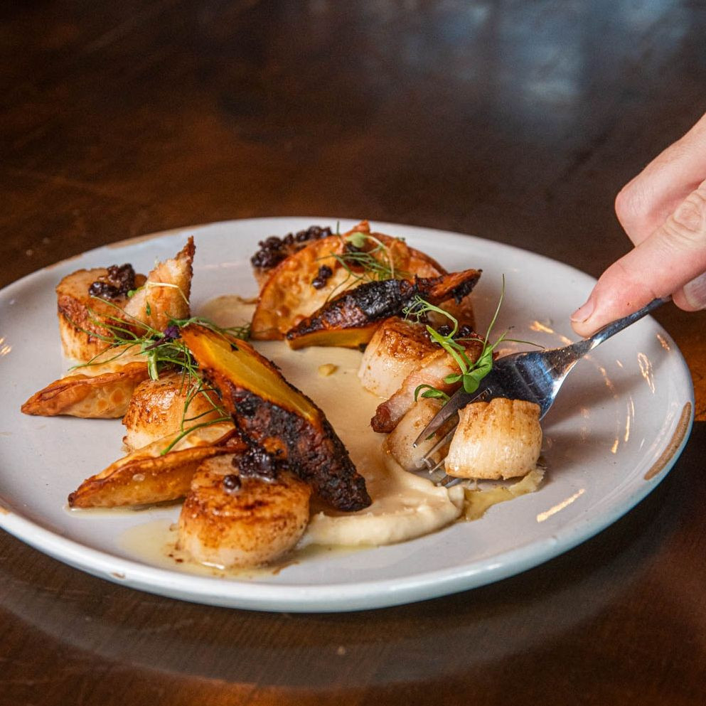 If you’re chasing the perfect forkful, start here: Pan Seared Diver Scallops with parsnip purée, butternut squash dumplings, braised bacon, and black currant vinaigrette. ❤️