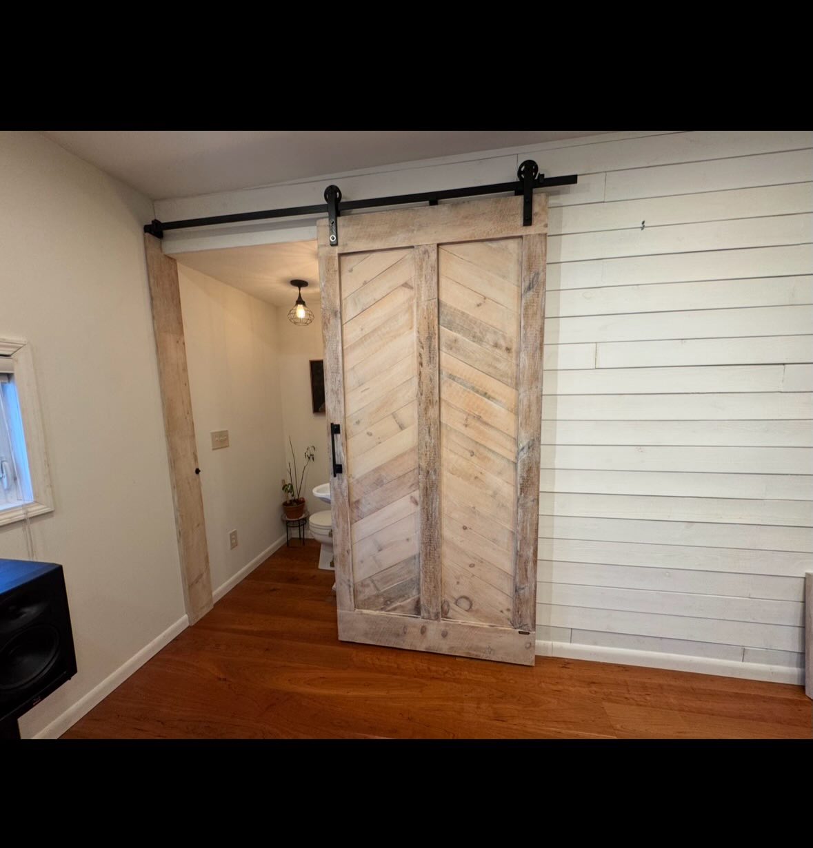 Matthew from North Attleboro needed a bathroom barn door for a finished space that is his studio off the main house.
The entryway ended on a perpendicular wall and so we fashioned a “post” for the door to end onto when closed. When doing these, doors need to “lip” over such posts, or some cases, such as this one, the door can end right on the post as long as it is 100% straight and plumb. Since walls—especially in New England—and trim work are not always 100% straight and true, we compensated by making the post fit to the contours of the wall and a slight lean that existed traveling upwards.
The custom barn door is a chevron styled rustic light-colored pine with white wax added for style. The door itself is 8 feet tall and we were able to compensate for other slightly off wall features in the space (such features do exist in many homes so this is actually the norm, but we know how to compensate for these things as professionals!)
In the end, the space has a lovely door that fits perfectly and adds style to the room!
Matthew runs Preservation Framer, which is a wonderful custom frame company in town. We both love reclaimed wood!
#pframer #northattleboro #rustic #barndoor #reclaimed