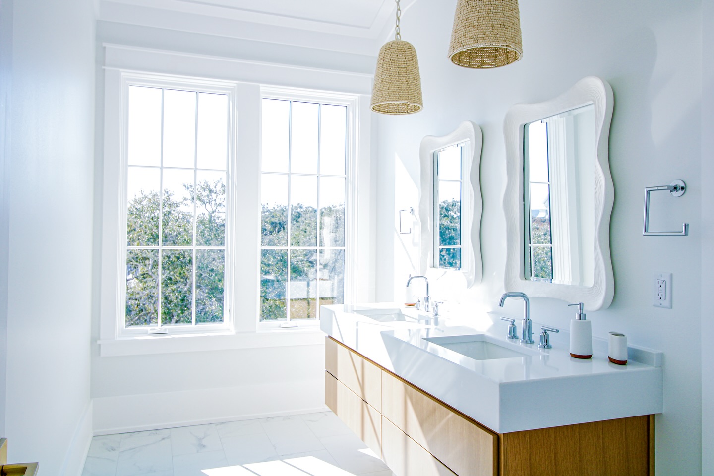 Bathed in natural light, this serene bathroom pairs sculptural mirrors with warm wood cabinetry and woven pendants, creating a quiet dialogue between texture, form, and simplicity.
#bathroom #interiordesign #naturallight #interiordesigner