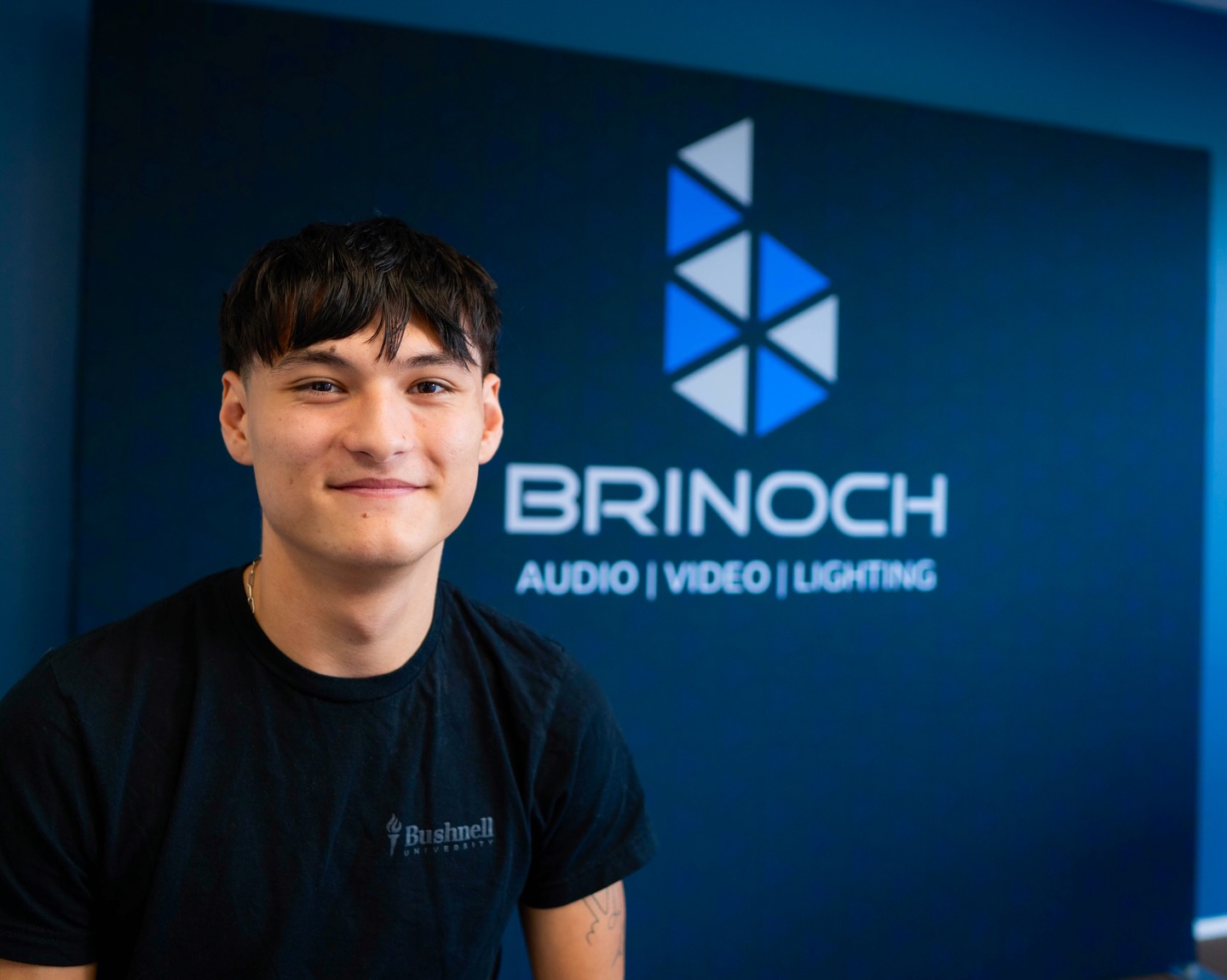 Nathan Griffiths gained hands-on technical experience through his fall internship with Brinoch, a company specializing in audio, video, and lighting system integration.
As a senior contemporary music industry major with an interest in live sound production, Nathan explored the setup and installation of PA (professional audio) systems by building equipment racks, soldering connections, and assisting with installation projects on job sites. His experience with Brinoch strengthened key technical skills while also teaching him the importance of preparation before installation.
For Nathan, his time with Brinoch emphasized the importance of seizing opportunities to step beyond campus and engage directly with professionals in the field. “I think it’s really great to get out of the Bushnell dome and go out into local businesses and actually start doing what you want to do in a field that’s related to what you want to do,” Nathan reflected. “It’s just good to get out and connect with people in the industry that you’re wanting to be a part of.”
Great work, Nathan! 👏
Watch the video on the Bushnell University YouTube!
Read the full article on the Bushnell website!
