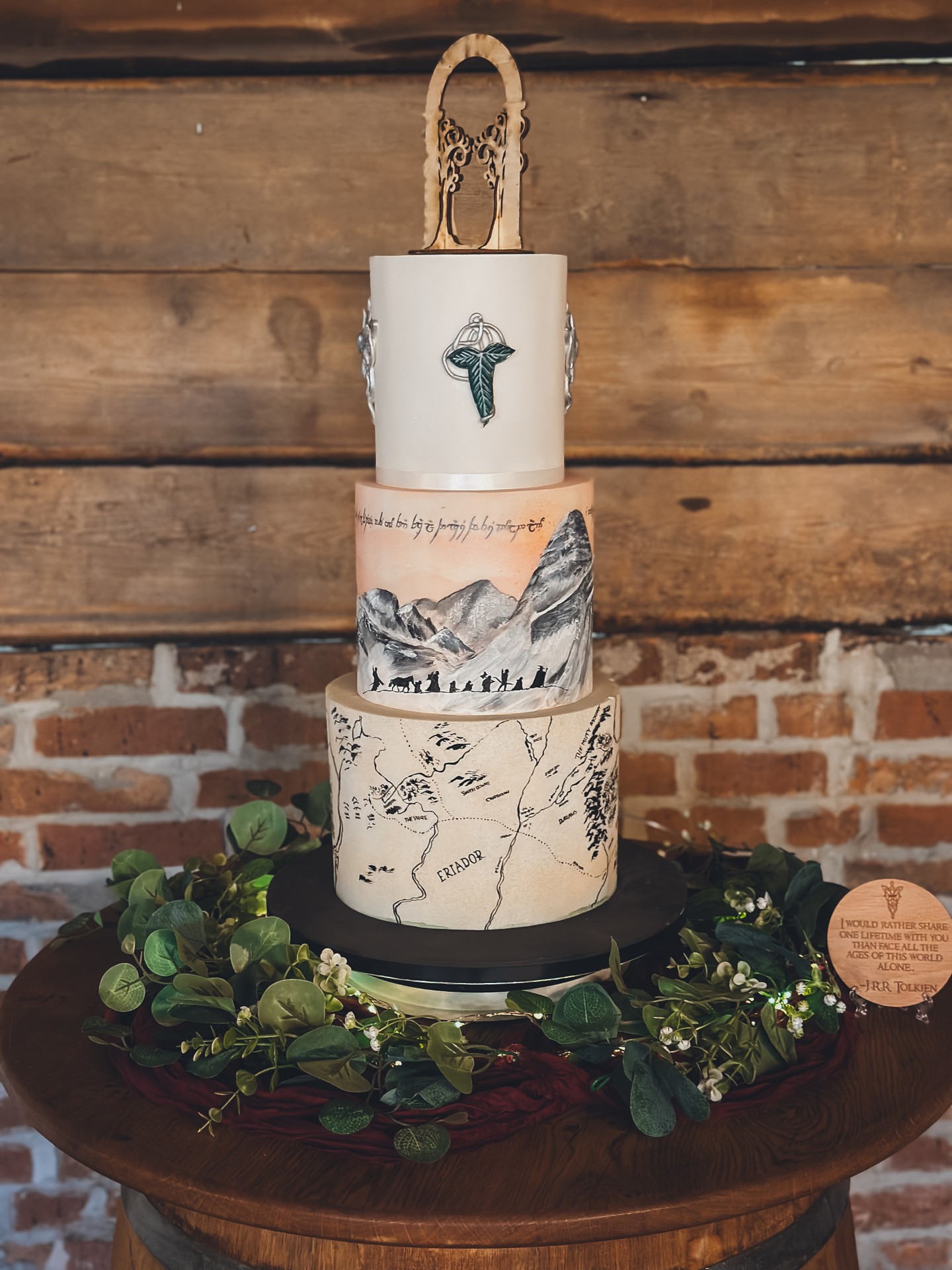 When your wedding cake is inspired by adventure, mythology and meaning… it deserves more than a generic design.
This bespoke piece was created around a shared love of fantasy storytelling and epic landscapes.
The details:
• Hand painted mountain scene wrapping the centre tier
• Script detailing etched across the skyline
• A vintage style map design forming the base tier
• Symbolic crest work and a custom topper to finish
Every element was designed around the couple’s story. Not trends. Not Pinterest. Their story.
That is the difference with truly bespoke design.
It is not about choosing from a catalogue.
It is about building something that feels personal, layered and intentional.
If you are planning a 2026 or 2027 wedding and want your cake to reflect who you are, not just what is popular, let’s design something meaningful together.
Explore the portfolio:
https://www.kimberlyjaynecakedesign.co.uk/portfolio
Enquire via the website to check availability 🤍
#BespokeWeddingCake
#AlternativeWeddingCake
#LuxuryWeddingDesign
#StoryLedWedding
#FantasyInspiredWedding