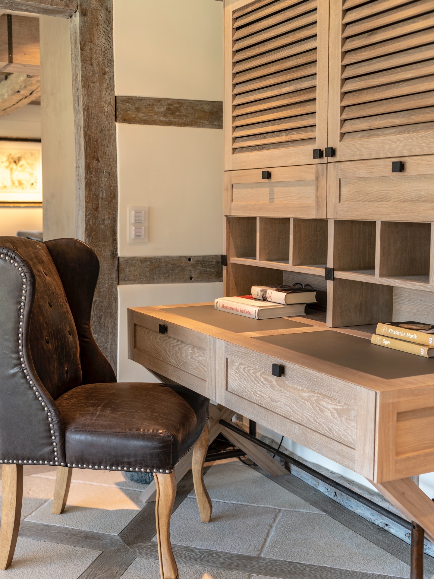 From morning focus to evening calm - the study reflects the quiet rhythm of country living.
Framed by authentic timber beams and softened by natural daylight, this workspace blends traditional craftsmanship with refined comfort. Warm oak surfaces, hand-finished details and structured joinery create a sense of order, while the rich leather chair adds depth and tactile warmth.
The result is an atmosphere designed for clarity, concentration and well-being - a place where work feels grounded and unhurried.
.
.
.
.
#LuxuryInteriors #InteriorDesignInspo #ModernCountryStyle #DreamHomeDesign #HomeOfficeGoals