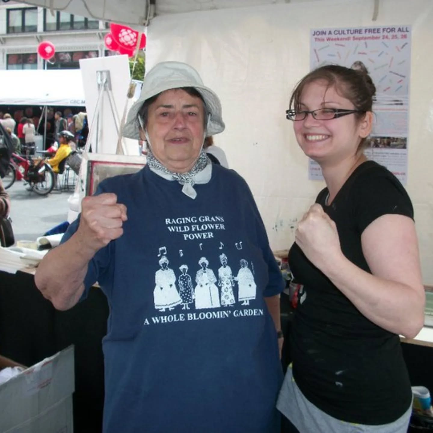 Happy International Women's Day from the inPrint Collective!
Sharing this very old photo from a 2010 Culture Days event where members from the Raging Grannies came and hung out with us while we live-printed some t-shirts. A treasured memory, for sure!
Keep raging and keep printing!
ID: a photo of two women, one a Raging Granny and one inPrint member Maureen, standing side by side and in an outdoor art booth, with smiles and raised fists.