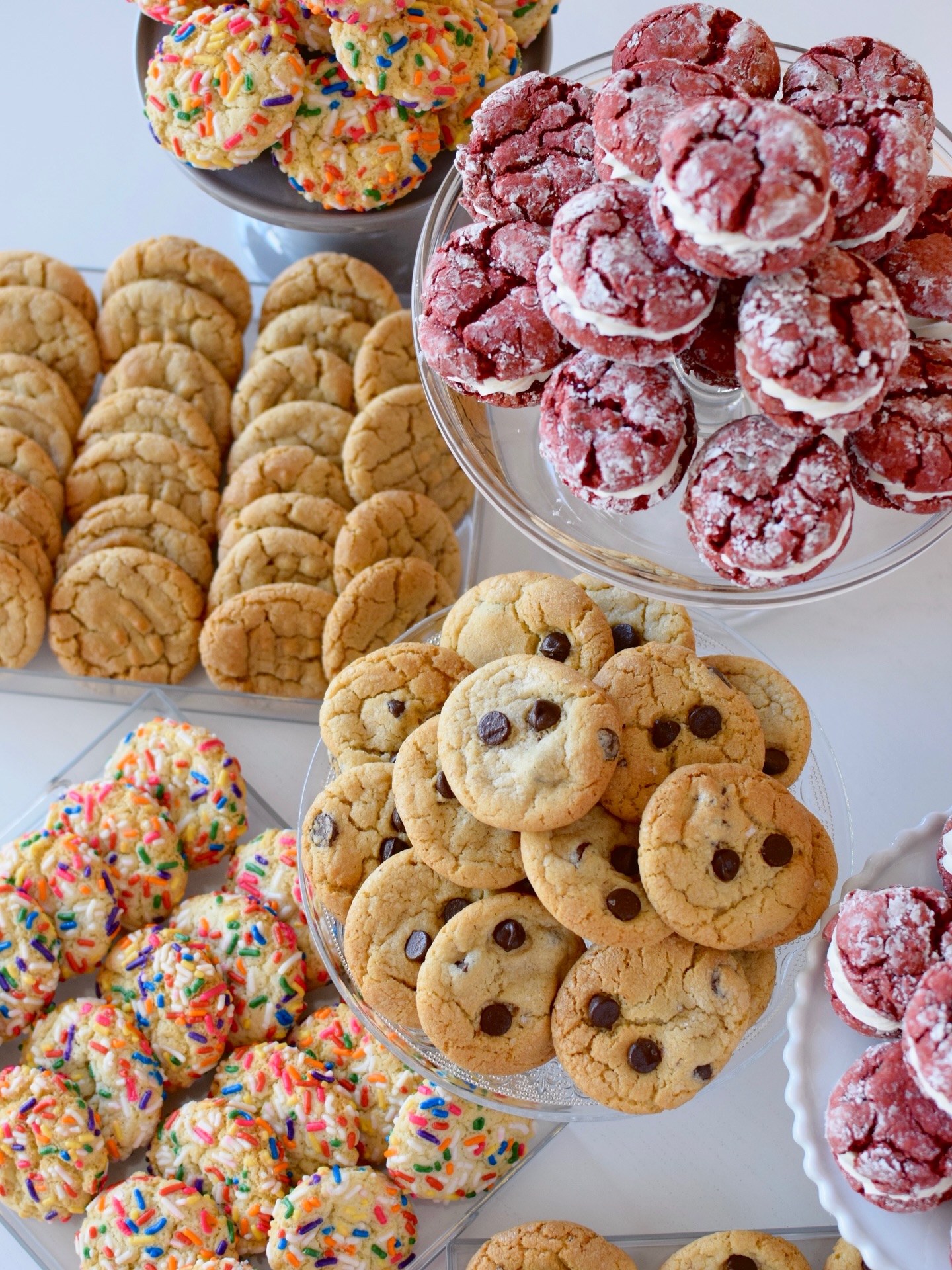 This is what a wedding dessert table looks like when the bride & groom are serious cookie lovers! 🍪 Heart-shaped cookie cake along with mini red velvet cookie sandwiches and mini confetti, brown butter chocolate chip & peanut butter cookies.
