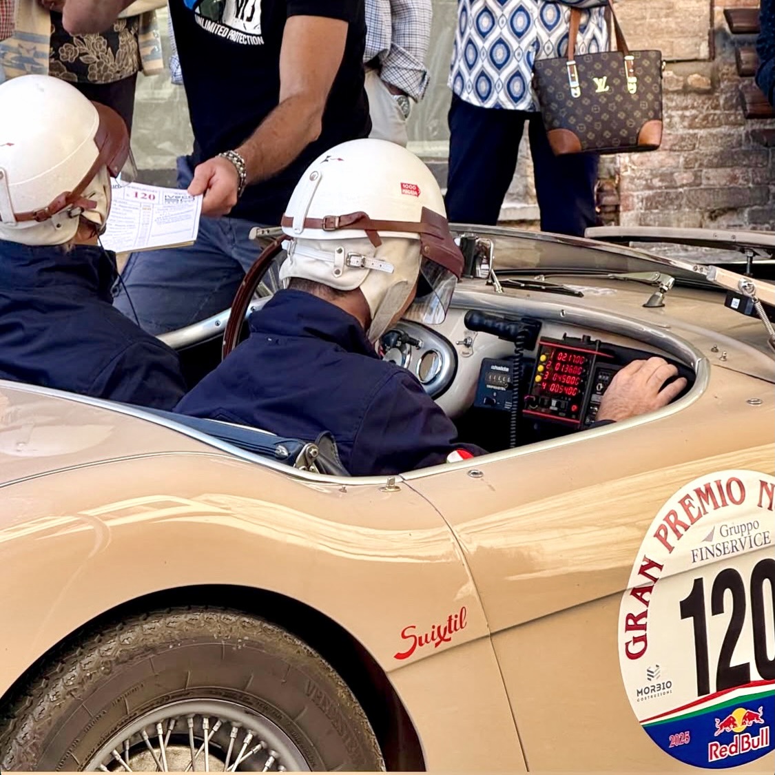 The Racing Queen at a checkpoint of the Gran Premio Nuvolari 2025: Our Austin Healey 100/4 in Coronet Cream with folded down windshield and racing helmets from @suixtil - a wonderful experience in Italy. #austinhealey #coronetcream #racingqueen1953 #classiccar #oldtimer
