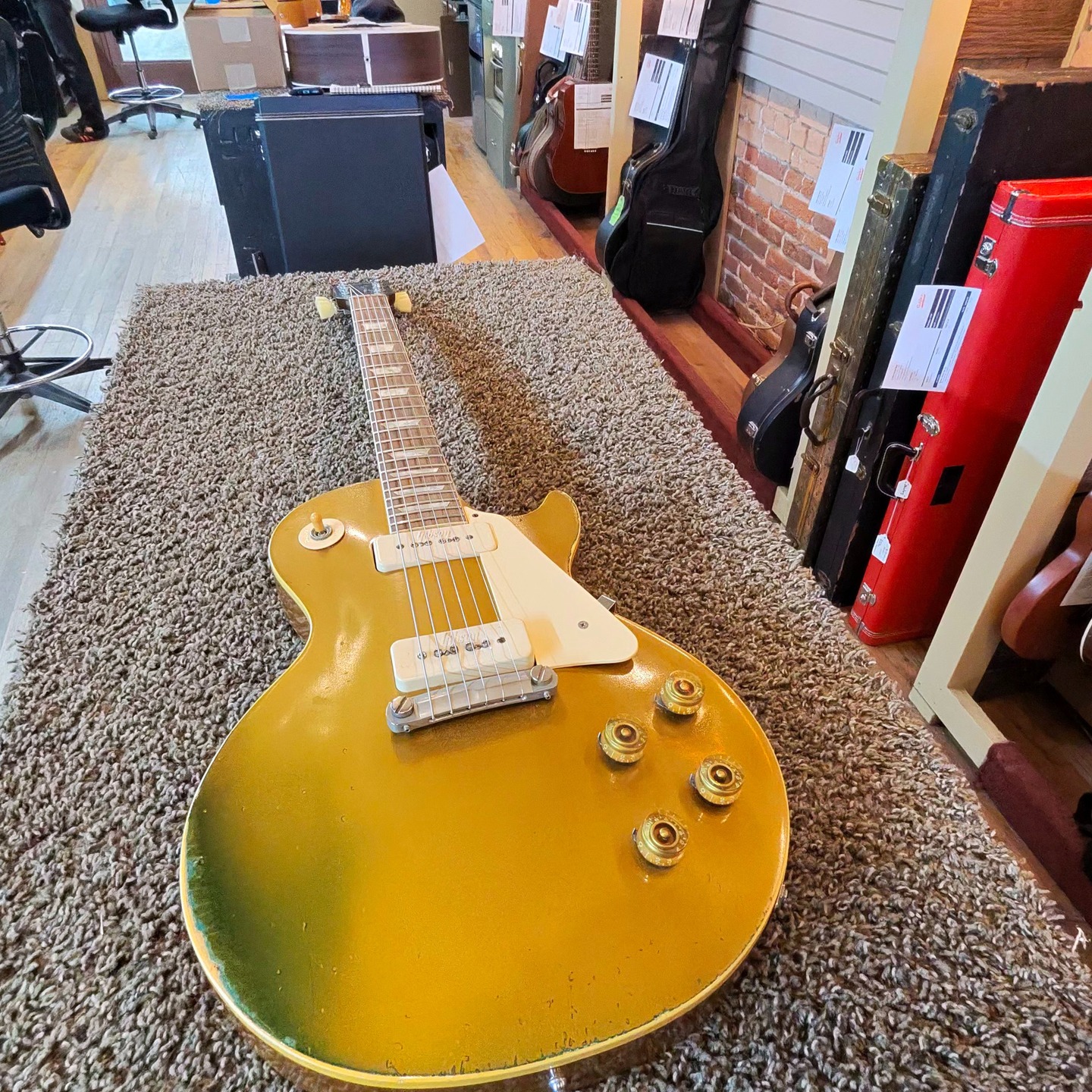 Check out this 1972 Gibson Les Paul Gold Top we have for sale in the shop.
The Gibson Les Paul Goldtop, introduced in 1952, is an iconic solid-body electric guitar featuring a distinctive bronze powder-based gold lacquer finish on a maple top with a mahogany back.
This guitar has the original case and the embossed pickup covers that were only produced in 1972 and 1973.
The bridge and tuners have been replaced, but the rest is all original.
Only 1,046 of these guitars were made in 1972.
This guitar is ready for your hands right now - so come on in if you are interested.