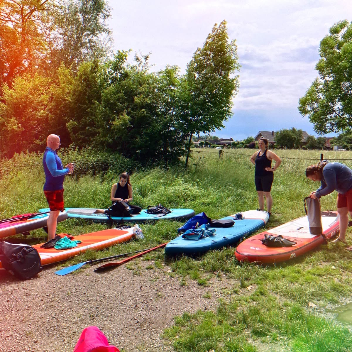 Durch die Natur auf dem SUP
An einem Sonntag Ende Mai machten sich 6 Naturathletinnen und -athleten mit ihren Stand up paddle-Boards auf den Weg zum Niederrhein. Von Wachtendonk aus sollte es über 27km auf der Niers bis nach Kevelaer gehen. Der vermeintlich anstrengendste Teil - das Aufpumpen der Boards - war bald geschafft und so ging es auf's Wasser, das nach viel Regen der letzten Wochen besonders hoch stand. Trotz intensiven Kniebeugensessions und Mobility-Übungen beim Training mussten deshalb die allermeisten Brücken doch im Knien unterfahren werden, um Beulen zu verhindern.
Entspannt ging es durch wunderschöne, teils unberührte Natur paddelnd, mal im Stehen, mal im Sitzen und begleitet von guten Gesprächen.
Nach etwa 13 km wurde dann in Geldern eine Pause gemacht, Energie getankt und dann weitergepaddelt.
Auf dem letzten Kilometer lernten wir die Natur noch von einer anderen Seite kennen. Bis dahin blickte die Sonne immer mal wieder zwischen mehr oder weniger dichten Wolken hindurch und es war angenehm warm - aber plötzlich wurden die Wolken immer dunkler und es begann zu regnen. Die Freude aller, relativ trocken am Ziel ankommen zu werden, erledigte sich nun ziemlich schnell, denn aus ein paar Regentropfen wurde ein ordentlicher Starkregen mit Wind von vorne links. So wurden die letzten etwa 10 Minuten Fahrt ohne viel Sicht, mit Gegenwind und Regen zu einem kraftraubenden Endspurt. Zum Glück wissen die Naturathletinnen und -athleten aber ja mit jedem Wetter umzugehen! Am Ziel packten alle erschöpft, aber auch glücklich zusammen und genossen noch eine Zimtschnecke bevor unsere erste Naturathleten-SUP-Tour offiziell endete. Demnächst geht's dann wieder mal mit den Stand up paddel-Boards auf's Wasser - seid gerne dabei!